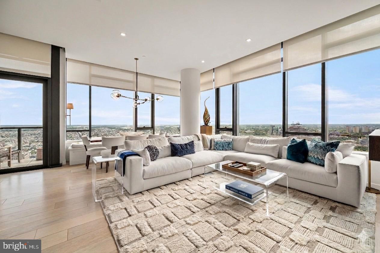 Perched high above the city on the 35th floor, The Sky Residence 2 (S2) is a dramatic three-bedroom, three-bath sanctuary where every moment feels cinematic. Wrapped along the coveted southwest corner, this extraordinary home captures sweeping panoramas of the Schuylkill River, where fiery sunsets pour through expansive floor-to-ceiling windows and bathe the living and dining spaces in golden light. For comfort and privacy this home features Lutron blinds, custom Roman shades and custom lighting all accessible with a push of a button.
Spanning more than 2,000 square feet, the residence unfolds with soaring 10-foot ceilings and a sense of effortless grandeur at every turn. Mornings begin in a bespoke European kitchen crafted with rich walnut cabinetry by Hans Krug, where sleek luxury meets impeccable function. Entertain with ease around the sculptural Calacatta Quartz waterfall island, complete with Dornbracht fixtures, an integrated Sub-Zero refrigerator, Wolf gas cooktop, steam oven, convection oven, Signature Series dishwasher, and discreet under-counter microwave drawer.
As evening falls, guests gather around the elegant wet bar before stepping onto the private balcony overlooking the glittering energy of Rittenhouse Square — a perfect stage for cocktails under the skyline.
The owner’s suite is a private retreat worthy of a five-star spa, featuring an expansive walk-in shower, dual vanities, a separate water closet, and refined Italian Fantini fixtures throughout. At its center, a freestanding soaking tub rests atop exquisite marble floors, framed by dramatic floor-to-ceiling porcelain walls, inviting indulgence at the end of the day.
Completing the residence is a dedicated laundry room with full-size Maytag washer and vented dryer, ensuring every detail of daily living is elevated to extraordinary. Outside of the home is an additional storage room for added convenience and one parking license to accommodate your car at the valet in our beautifully appointed motor court.
