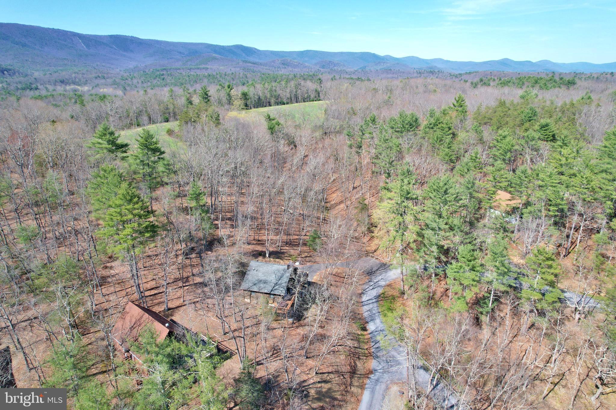 NEEDS WORK - Welcome to "Hogan's Tree Top," a charming chalet offering easy access and paved roads, located less than 3 miles from the resort clubhouse. This delightful 3-bedroom, 1.5-bathroom chalet has been recently updated with new windows, new flooring, new cabinets, countertops and appliances, making it move-in ready. The furniture can convey with a reasonable offer, adding to the convenience.
The cozy interior features a wood-burning fireplace, perfect for relaxing after a day of skiing, swimming, mountain biking, or golfing—all just minutes away. The open floor plan and updated kitchen provide a comfortable and inviting space for family and friends. Step outside to enjoy dinners on the deck, overlooking the serene treetop views. While the property is being sold as-is, it offers a fantastic opportunity for investors or those looking to flip a home. The outdoor decking and exterior paint need some love, but with a little care, this chalet can truly shine. Its prime location, perfectly close to Bryce Resort, adds to its appeal. Priced to sell, "Hogan's Tree Top" is a unique opportunity to own a piece of resort living. Bryce Resort area offers the following: Small Airport, Library, Dog Park, Indoor Pool, Swimming Pool, Inground Outdoor Swimming Pool, Lazy River, Pickleball, Tennis, Playground, Golf, Mini Golf Lake, Mtn Biking, Skiing, Snowboarding, Ice-Skating Rink, Restaurants to name a few. 1.5 hours from NoVA. There is a farmers' market on Wednesdays during the summer. Call now for appt.