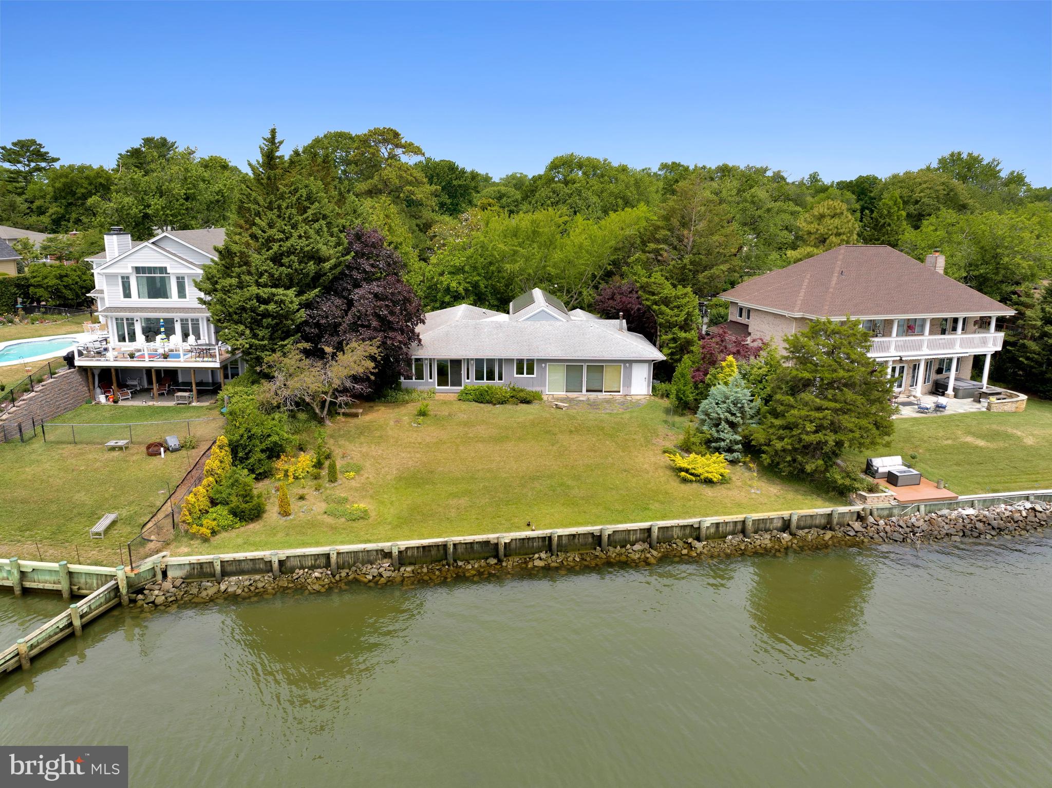 ** Rare Mid-Century Modern Waterfront Sanctuary on Bay View Drive ** Welcome to 129 E Bay View Drive, an authentic 1954 mid-century modern masterpiece offering a rare combination of 2,852 square feet of seamless, single-level living and an elite 102 feet of premium shoreline. Perched safely outside the high-risk flood plain, this property delivers a rare blend of elevated peace of mind and significant annual insurance savings not shared by many neighboring waterfront properties. ** The 102 feet of bulkheaded shoreline features a pristine water entry point, perfectly suited for launching kayaks, paddleboards, or rowing shells directly into the scenic waterways. ** Designed for the design purist and luxury downsizer alike, the home flows effortlessly across an expansive one-level footprint. At the heart of the residence is a masterfully restored 1954 kitchen featuring iconic, authentic Geneva steel cabinetry, a celebrated testament to mid-century industrial design. ** In place of a standard garage, the home boasts a spectacular, museum-grade botanical conservatory flooded with natural light from specialized skylights. This architectural feature transforms the traditional parking footprint into a world-class, climate-controlled indoor oasis, perfect for the avid collector, artist, or green thumb. ** Floor-to-ceiling vistas frame the sweeping water views, leading out to a beautifully manicured lot. Positioned perfectly for DC and Northern Virginia professionals seeking a sophisticated weekend retreat, or locals looking to "right-size" without sacrificing premium water access. Complete with floor plans and site surveys ready for your review. Schedule your private tour today. Welcome!