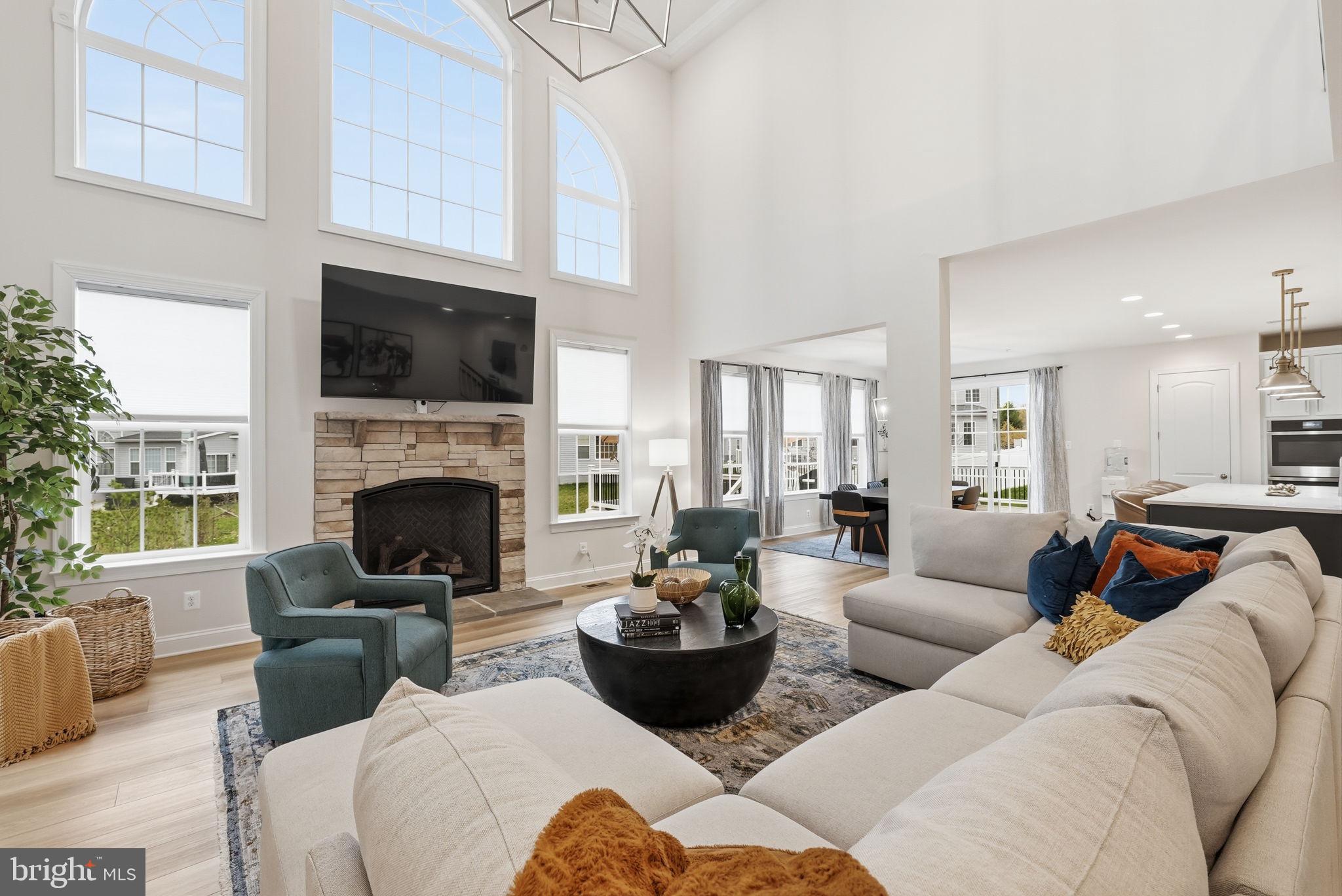 Welcome to a home where timeless elegance meets modern living. Perfectly positioned on a quiet cul-de-sac and surrounded by mature landscaping, this stunning stone-front residence offers a rare combination of sophisticated design, flexible living spaces, and resort-inspired outdoor amenities. From the soaring ceilings and sun-filled interiors to the gourmet kitchen, luxurious primary suite, finished lower level, and private wooded backdrop, every space has been thoughtfully designed to elevate both everyday living and special occasions.

Inside, a dramatic two-story foyer welcomes you with a striking waterfall staircase and modern contrasting finishes. The main level features a private home office, formal living room, and elegant dining room accented by crown molding and chair rail detailing. At the heart of the home, the impressive two-story family room showcases a coffered ceiling, expansive wall of windows, and a stunning gas fireplace with custom mantel, creating a warm and inviting gathering space.

Designed for both entertaining and daily living, the gourmet kitchen features a large quartz island with seating, a 36-inch gas cooktop, premium stainless steel appliances, custom 42-inch cabinetry, designer pendant lighting, farmhouse sink, and abundant prep space. The adjacent morning room flows seamlessly into the main living areas, while a custom mudroom and alternate laundry location add convenience and functionality.

Upstairs, four generously sized bedrooms include a luxurious primary suite with a tray ceiling, custom walk-in closet, and spa-inspired bath featuring dual vanities, a soaking tub, and an upgraded walk-in shower with custom tilework and built-in seating. A secondary bedroom suite with a private bath provides flexibility for guests or multigenerational living, while a buddy bathroom serves the remaining bedrooms. Designer fixtures, brushed nickel hardware, and plush carpeting continue the home's upscale appeal throughout.

The fully finished lower level expands the living space with a large recreation room, dedicated exercise room, full bathroom, and abundant storage. A double areaway with a sliding glass door provides walk-up access and fills the space with natural light, making it ideal for entertaining, hobbies, fitness, or overnight guests.

Beyond the impressive features, this home was designed for the way people live today. Host holiday gatherings in the soaring family room, prepare meals while staying connected around the oversized kitchen island, or enjoy movie nights, celebrations, and everyday moments with room for everyone. The versatile floor plan easily accommodates working from home, extended family, guests, and evolving lifestyle needs.

Outdoor living is equally inviting. Enjoy morning coffee on the expansive composite deck overlooking peaceful wooded views, host summer cookouts on the stamped concrete patio, or gather around the built-in fire pit beneath the glow of professionally installed landscape lighting. The private backyard setting offers a welcome retreat from the pace of everyday life.

With 9-foot ceilings on all three levels, high-efficiency natural gas heat, Low-E windows, and a HERS-certified building envelope, this home delivers comfort, efficiency, and quality craftsmanship throughout. Homes offering a private cul-de-sac location, a two-story family room, main-level office, secondary bedroom suite, finished basement, premium outdoor living spaces, and wooded privacy rarely become available in one complete package.

Ideally located near major commuter routes, shopping, dining, recreation, and everyday conveniences, this exceptional property offers the perfect balance of accessibility and tranquility. More than just a beautiful home, it is a place to gather, celebrate, and create lasting memories. Opportunities like this are increasingly rare—schedule your private tour today and experience everything this remarkable home has to offer.
