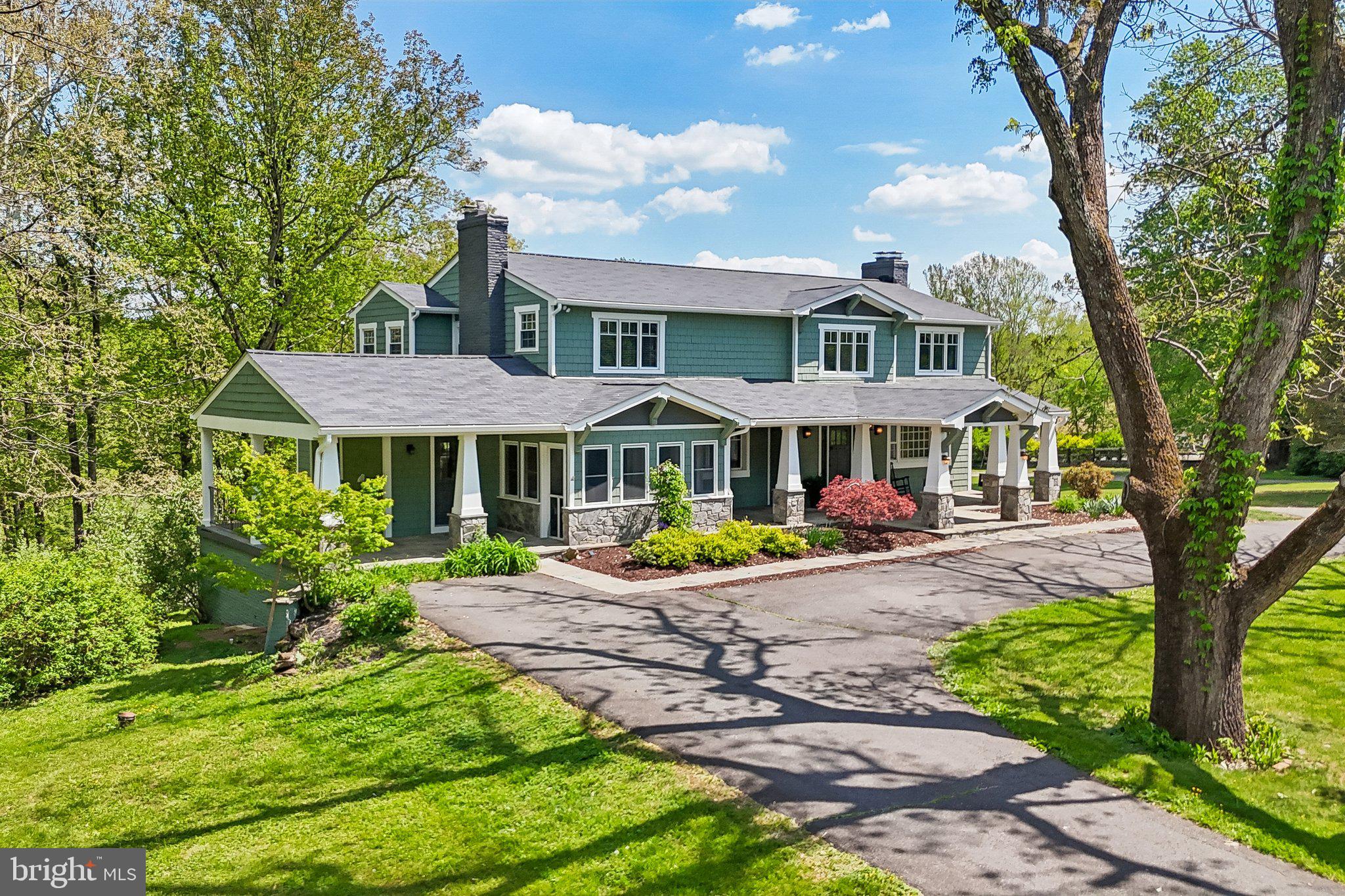 ***Catered Open House Saturday (5/30) 11am-1pm and Sunday 5/31 11am-1pm*** Are you ready for a home to steal your heart?
Some homes give you square footage. This one gives you a whole way of living. Set on 5 gently rolling acres in Clifton, this Arts & Crafts farmhouse has the kind of curb appeal that actually slows you down: broad covered porches, gabled rooflines, shingle-style HardiePlank, tapered stone columns, and deep green surroundings that make the house feel grounded in the landscape.
Once  you step inside it gets even better. More than 5,700 finished square feet. a finished lower level, 4 bedrooms, and 3.5 baths create room to spread out, come together.
The kitchen is the kind of space people drift toward naturally, with warm wood cabinetry, long granite surfaces, generous seating, and sightlines that keep the cook part of every conversation. It opens beautifully to the main living spaces.  Dinner parties feel easy and mornings feel unrushed.
Beyond the kitchen,  the 2016 great room addition absolutely changes the mood of the home: soaring beamed ceilings, built-ins, window seats, fireplace, and walls of glass that pull the outdoors in all day long. 
The Master Bedroom has a spa-like en suite with a soaking tub, glass shower, and the kind of natural light most people hope for and rarely get.
The finished lower level adds another comfortable destination for movie nights, game days, creative projects, or long weekends when everyone wants room to relax.
The original addition in 2006 gave the home real presence and scale. In 2026, the main roof was replaced, the barn roof was replaced, the entire exterior was painted, and the entire interior was painted, giving the next owner a polished start with major work already done, and there is no HOA.
Another unique and special aspect of this property is the converted barn. In 2024, this county-approved ADU has a beautiful open concept living space complete with a deck overlooking the pond.  With its own driveway, full kitchen, open beam ceiling gathering room, bedroom, and bath, it adds rare flexibility for guests, creative work, multi-generational living, extended stays, private work-from-home setup, or substantial additional rental income. 
The property keeps unfolding. A large deck, covered terrace, hot tub, gazebo, pond, and renovated dam completed in 2006 turn the outside  into something far more memorable than "yard space." The front porch feels like an arrival, while the rear deck and covered patio give you two completely different ways to enjoy the landscape. There is room here for dinners that stretch past sunset, coffee with a view of the trees, afternoons by the water, and the simple luxury of hearing more birds than traffic.

This property has another unique feature. An additional 7-acre buildable parcel is available.  That  parcel comes complete with hiking trail, open space, and Johnny Moore Creek, creating the opportunity for an even more substantial Clifton holding. Plans are also available for a future two-car garage. For someone wanting both, 

And the Clifton location is a huge part of the story. Historic Clifton still keeps its small-town character, with Main Street lined by century-old buildings and a compact mix of local shops and eateries. Burke Lake Park offers a 218-acre lake, 5.25 miles of fishing shoreline, and a 4.68-mile trail around the water, while Hemlock Overlook Regional Park adds wooded trails and scenic water views.

Paradise Springs Winery adds another nearby destination, and the Colonnade at Union Mill puts daily conveniences like Giant Food and Panera within easy reach. This is the rare home that feels expansive without losing warmth, impressive without feeling formal, and private without feeling isolated. It is a place for big moments, slow mornings, and the kind of everyday beauty that changes how home feels.