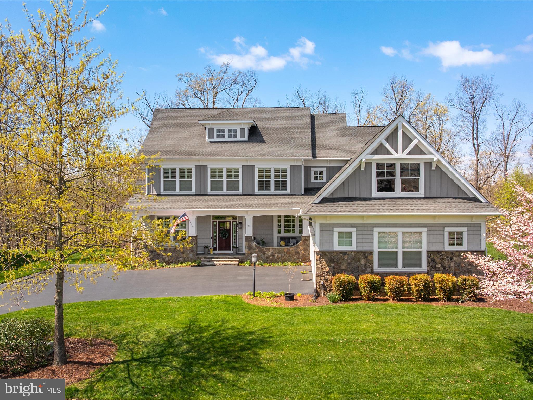 This inviting home sits at the end of a quiet cul-de-sac, offering a peaceful retreat with stunning views of Lake Manassas. A spacious front porch welcomes you in and is the perfect spot to relax and take in the beautiful surroundings. Inside, hardwood floors run throughout the main and upper levels, and craftsman-style trim adds a touch of character and warmth. The large foyer opens to a spacious formal living room and a grand dining room, with windows framing the lake view. A main-level bedroom with a full bath offers flexible space for guests or a home office. The kitchen is both functional and stylish, featuring white upgraded cabinetry, a custom tile backsplash, stainless steel appliances, and a walk-in pantry. It opens to a cozy family room with built-in shelving and a gas fireplace. Just off the kitchen eating area and family room is a covered back porch that feels like an extension of the living space—perfect for outdoor dining or simply enjoying the peaceful view of the backyard, trees, and lake.
Upstairs, the spacious primary suite offers a private retreat, complete with a sitting area, two walk-in closets, and large windows that bring in natural light and lake views. The en suite bathroom includes two separate vanities, a soaking tub, a large walk-in shower, and a private water closet. Two secondary bedrooms share a Jack-and-Jill bathroom, and a fourth bedroom has its own private bath. The laundry room is conveniently located on the upper level. The finished walkout basement adds even more space with a large rec room and fireplace, a media room, a sixth bedroom with attached bath, and finished storage. This home sits on a half-acre lot that backs to woods and open space, with wide-open lake views and sunsets that make it feel like a year-round getaway. Comfortable, spacious, and full of charm—this is lakeside living at its best. 
This unique neighborhood offers resort-style living with over 100 acres of open space, walking trails, a lakeside pool, fire pits, and a log-hewn pavilion. Residents can also fish from the shores of Lake Manassas. This exceptional home is tucked away yet conveniently located just minutes from shopping, restaurants, entertainment venues, transportation, and top-rated schools. Don't miss the chance to own this unique property in the coveted Saranac community.