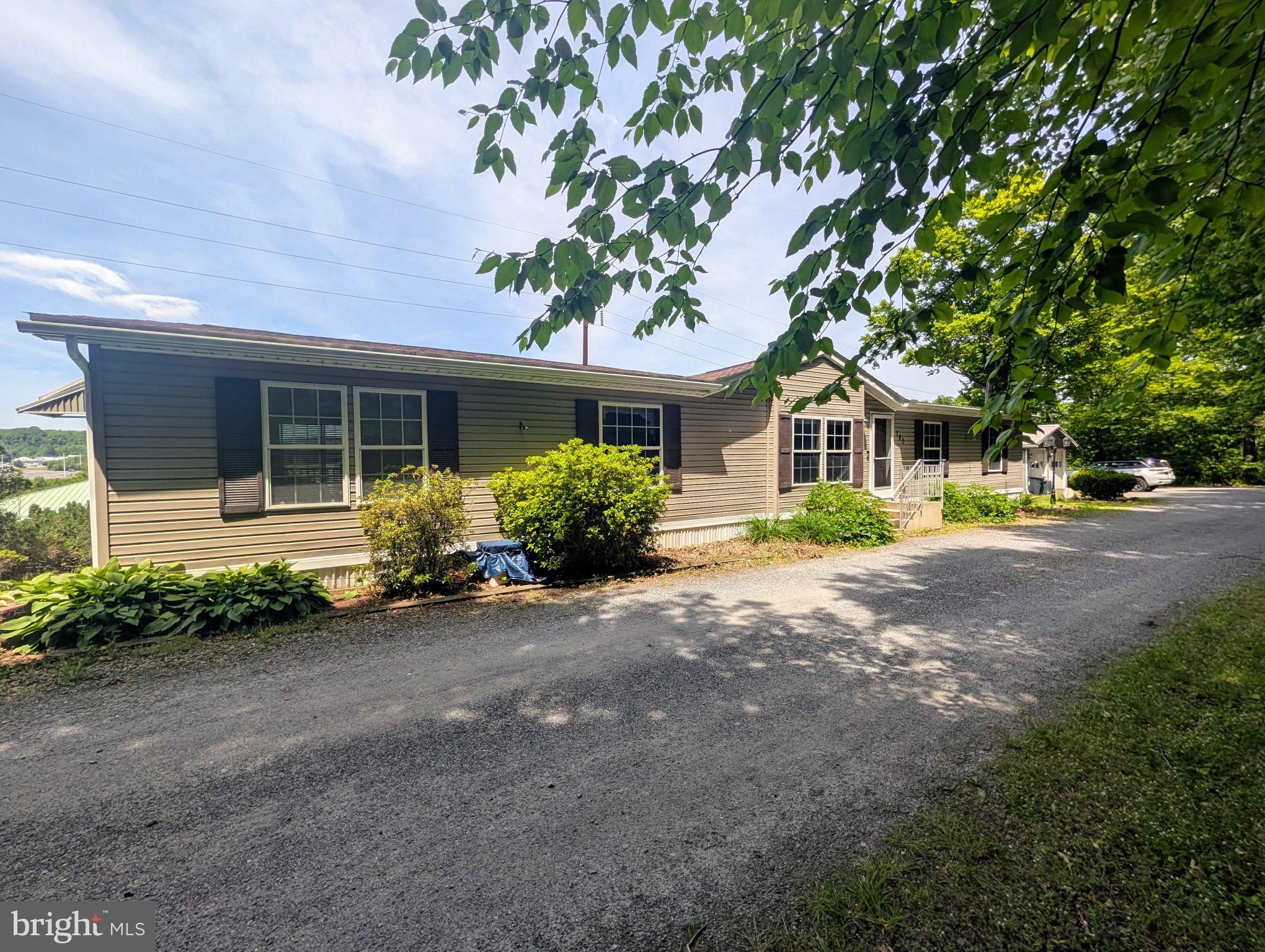 Tucked among the trees at the end of a private road, this hidden gem is a spacious 3-bedroom, possible 4-bedroom, 2-full-bath manufactured home with thoughtfully designed additions that create generous living spaces throughout, offering the perfect blend of privacy, scenic views, and spacious living. Overlooking the St. Clair area, you'll enjoy beautiful long-range views and even occasional distant fireworks displays. 

Step inside to discover a bright, open-concept floor plan designed for both everyday living and entertaining. The spacious living room, dining area, and kitchen flow seamlessly together, creating a welcoming gathering space for family and friends. The centrally located kitchen features an island, beverage bar, walk-in pantry, abundant cabinetry, double sink plus all appliances remain.

The impressive family room addition is filled with natural light from a dramatic wall of windows, complemented by decorative triangular accent windows that frame the surrounding views. A freestanding propane fireplace creates a warm and inviting atmosphere, while sliding glass doors on both ends of the room provide access to the outdoors and a sunroom/enclosed porch that leads to an additional deck.

The private primary suite is a true retreat featuring a spacious bedroom addition, freestanding propane fireplace, a wall of windows topped with cathedral-style accent windows, sliding glass doors to a private deck showcasing the scenic views, a walk-in closet, full bath, and a sitting area perfect for relaxing, reading, or creating your own personal sanctuary.

Located on the opposite end of the home are two additional bedrooms, a second full bath, laundry room with washer and dryer included, and a generous storage closet.

Just off the living room, a versatile bonus room could potentially serve as a fourth bedroom, office, guest room, hobby room, playroom, or additional living space.

Outside, the peaceful setting, scenic views, decks, detached two-car garage, storage shed, and ample off-street parking continue the appeal of this hidden retreat surrounded by nature. If you've been searching for a home that offers privacy, views, flexible living space, and room to unwind, this hidden gem is one you won't want to miss. 

Offering the best of both worlds, this private retreat provides a peaceful setting while remaining just minutes from shopping, dining, and everyday amenities.

Lot rent is $350 per month and includes road maintenance.