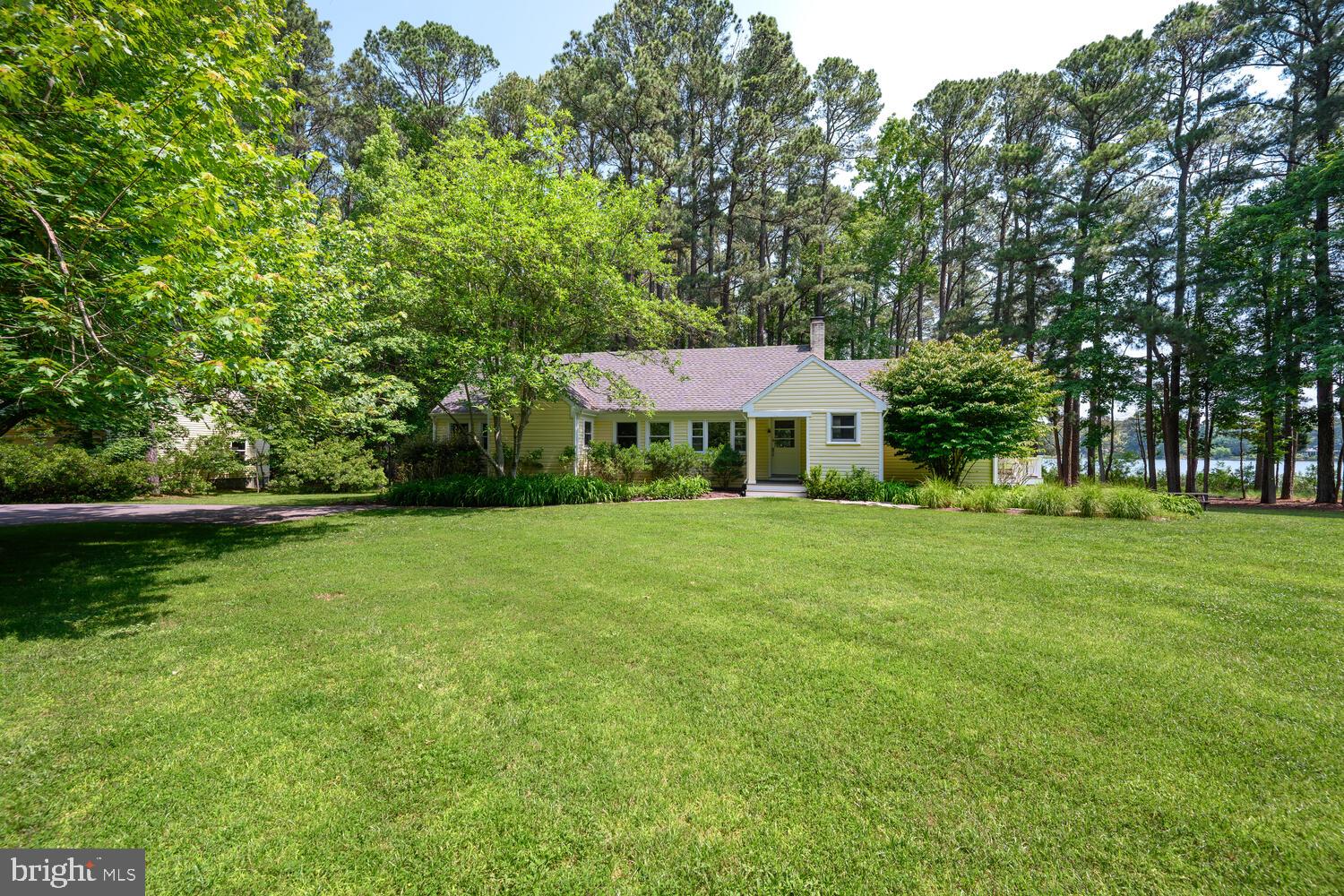 Nestled beneath a canopy of mature pines along the protected waters of Solitude Creek, this beautifully renovated waterfront retreat captures the timeless appeal of Maryland's Eastern Shore. Occupying approximately 2.745 private acres with nearly 200 feet of shoreline, the property offers an exceptional blend of privacy, boating, and relaxed luxury—just minutes from the historic waterfront town of St. Michaels.
Renovated in 2020, the residence pairs classic coastal architecture with bright, contemporary interiors designed to embrace natural light and peaceful water views.   Spanning approximately 2,100 square feet, the home offers four bedrooms and two-and-a-half baths, all arranged on a single level for effortless everyday living. Warm hardwood floors, custom millwork, and an inviting fireplace create an atmosphere that is both elegant and welcoming, while expansive windows frame the surrounding landscape and shimmering creek beyond.

At the heart of the home, a beautifully appointed gourmet kitchen features custom cabinetry, granite countertops, a generous center island, and vaulted ceilings that flow seamlessly into open dining and living spaces.   Created for gathering with family and friends, these light-filled interiors extend naturally onto an expansive waterside composite deck—an ideal setting for morning coffee, sunset cocktails, or alfresco dinners overlooking the water.

The primary suite offers a beautifully finished bath, while three additional guest bedrooms provide comfortable accommodations for family and visitors.  Every room reflects a timeless aesthetic that complements the property's serene waterfront surroundings.
A private pier with a 9,000-pound boat lift and approximately 6 feet of mean low water offers exceptional boating for a wide variety of vessels.  The property's seamless connection to the Choptank River and surrounding tributaries creates a waterfront lifestyle defined by both privacy and adventure.  Whether arriving by boat or by car, few locations offer such a remarkable balance of seclusion, convenience, and direct access to some of the Eastern Shore's most celebrated waterways.
A detached two-car garage with loft space above provides abundant storage and flexibility for hobbies, a workshop, or future possibilities.  Mature landscaping, towering pines, and exceptional privacy complete this rare waterfront offering.
The adjacent 3.21± acre waterfront lot to the north is also available for purchase at $895,000.   Additional information is available from the listing agent upon request