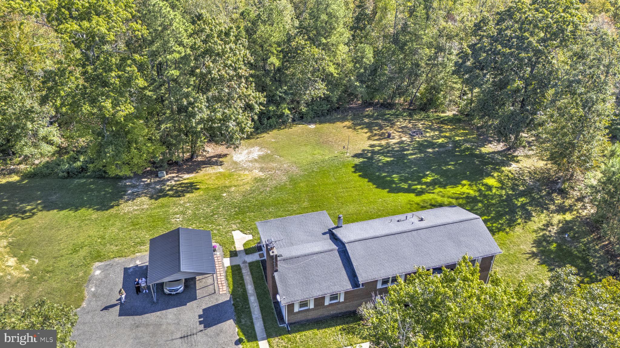 Nestled on 29.5 acres of serene, wooded privacy, this exceptional estate offers a rare blend of character, modern updates, and endless potential. Inside the 2,700+ sq ft home, you’re welcomed by distinctive features like a striking cedar beam and dual staircases that add warmth and architectural charm. The spacious kitchen is a standout, featuring granite countertops, stainless steel appliances, tile flooring, and abundant cabinetry—perfect for both everyday living and entertaining.

The home offers generously sized bedrooms, an updated guest bath, and a luxurious owner’s suite complete with a walk-in closet and a beautifully renovated en-suite with floor-to-ceiling tile and a walk-in shower. The main level provides multiple gathering spaces, including a formal dining room, a large family room, and a unique all-season room filled with natural light.

The finished basement expands your living space with a cozy wood stove, three additional bedrooms, and a fully updated bathroom—ideal for guests or flexible living needs. Outside, two open field areas offer endless opportunities for recreation, gardening, or even horses, while the detached workshop with its own 200-amp service is perfect for hobbies, storage, or projects.

With major updates including a newer roof, HVAC system, well pump, and hot water heater, this home offers peace of mind along with its natural beauty—all just minutes from shopping, dining, and Pax River.