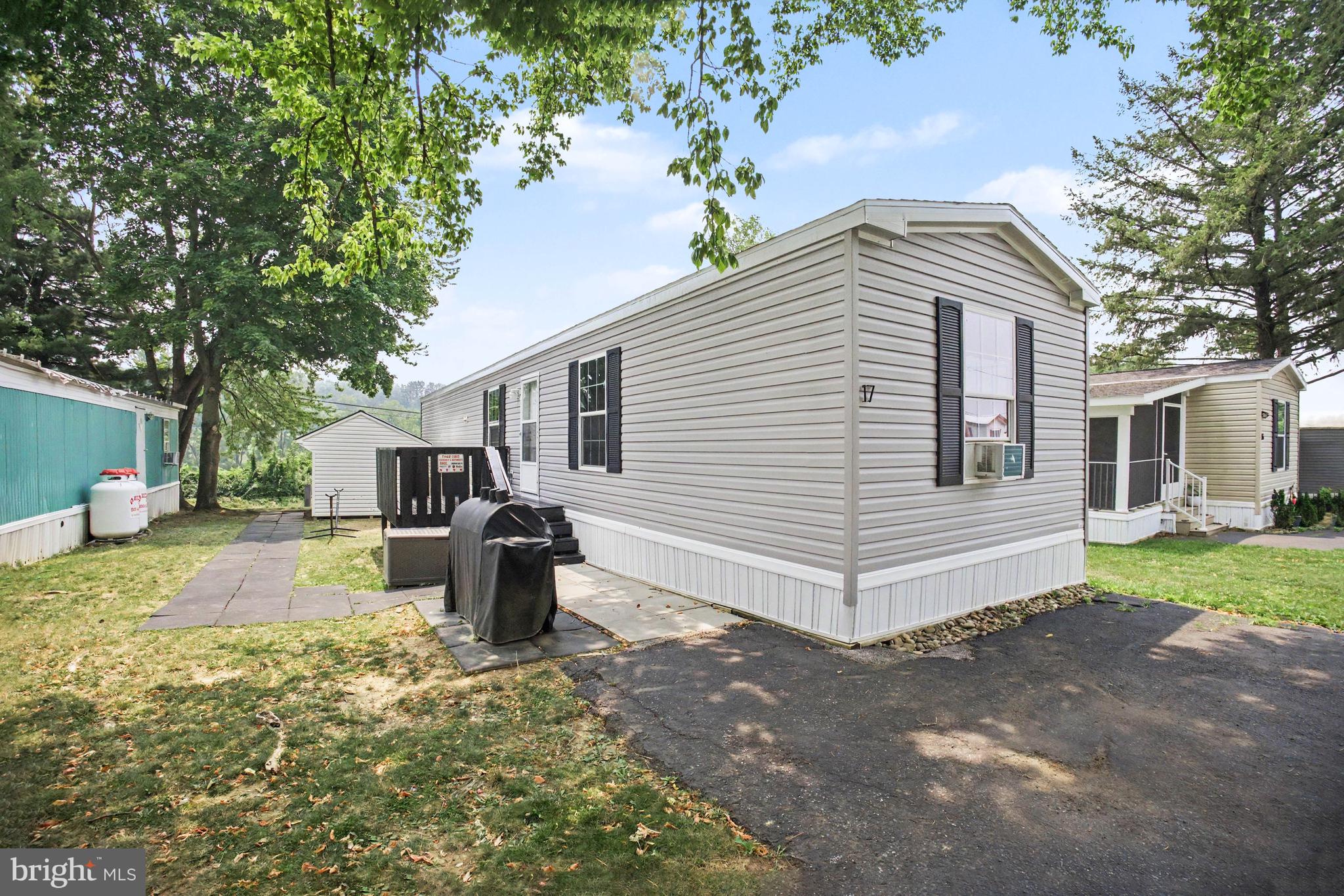 Welcome home to 17 Lebanon Valley Court! Built in 2023, this beautifully maintained Champion single-wide manufactured home offers 3 bedrooms, 2 full bathrooms, and nearly 1,000 sq ft of bright, functional living space. Arrive to off-street parking for two vehicles, a freshly painted deck perfect for relaxing, and a spacious 10x16 shed providing exceptional storage. Step inside to an inviting open-concept layout where the family room flows seamlessly into the kitchen—complete with a breakfast bar, stainless steel appliances, and a convenient dedicated laundry room (washer and dryer included!). The popular split-bedroom floor plan features a private primary suite in the rear with its own full bathroom, while two additional bedrooms and a second full bath are situated on the opposite end of the home for optimal privacy. Best of all, enjoy total buyer peace of mind with a transferable 7-year manufacturer warranty valid through 2030. Monthly lot rent is $515/month (water and sewer are billed separately through the park). Schedule your showing today!