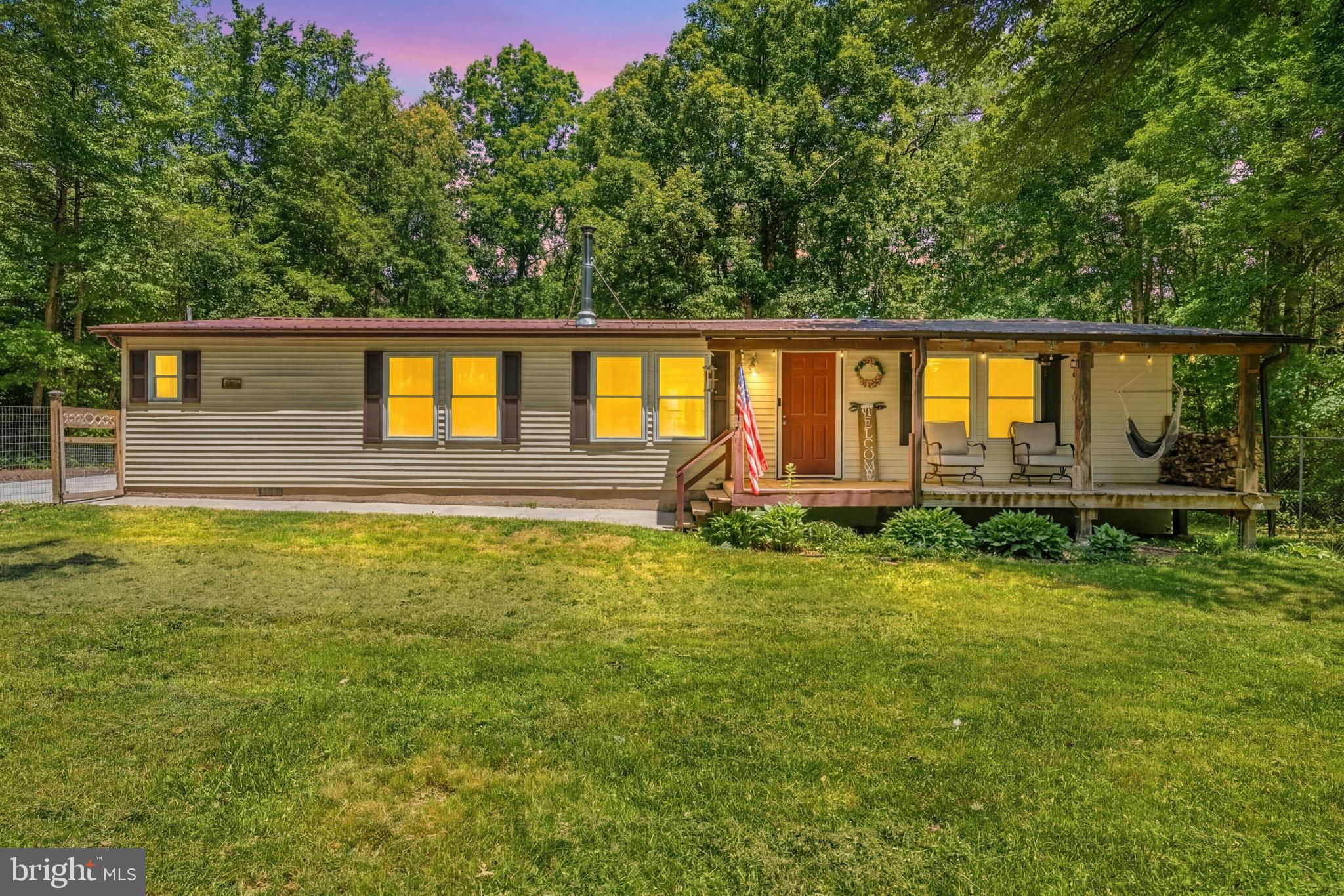 Privately positioned on 3 acres backing to wooded privacy, this updated Nanjemoy home offers the perfect combination of country living, modern updates, and flexible outdoor space. The 1,512 square foot home features 3 bedrooms, 2 full baths, and an oversized parking pad perfect for multiple vehicles, RV storage, boat storage, trailers, and more. Inside, the open layout with vaulted ceilings offers a spacious combination living room, dining area, and family room ideal for everyday living and entertaining, and features an updated kitchen and baths, new LVP flooring, and fresh paint. The inviting living space is further enhanced by a wood-burning fireplace, creating a warm and comfortable focal point for relaxing evenings. The split-bedroom floor plan provides added privacy, with the primary suite and private bath located on one side of the home and bedrooms two and three situated on the opposite side. Outdoor living spaces include a covered front porch overlooking the fenced front yard and a large rear deck overlooking wooded privacy — perfect for entertaining a crowd of any size, enjoying your morning coffee, or relaxing with your favorite beverage at the end of the day. The expansive yard offers endless possibilities for hobbies, gardening, recreation, or simply enjoying the peaceful setting. Bring your RV, boat, trailers, UTVs, and extra vehicles — this property offers the space and freedom to truly enjoy country living your way. Conveniently located near MD Rt. 210, the Waldorf area, the Woodrow Wilson Bridge, I-95/I-495, and historic Port Tobacco, this property offers a private setting while still providing convenient access to Washington DC and surrounding areas as well as Northern Virginia.  Mortgage savings may be available for buyers of this listing.