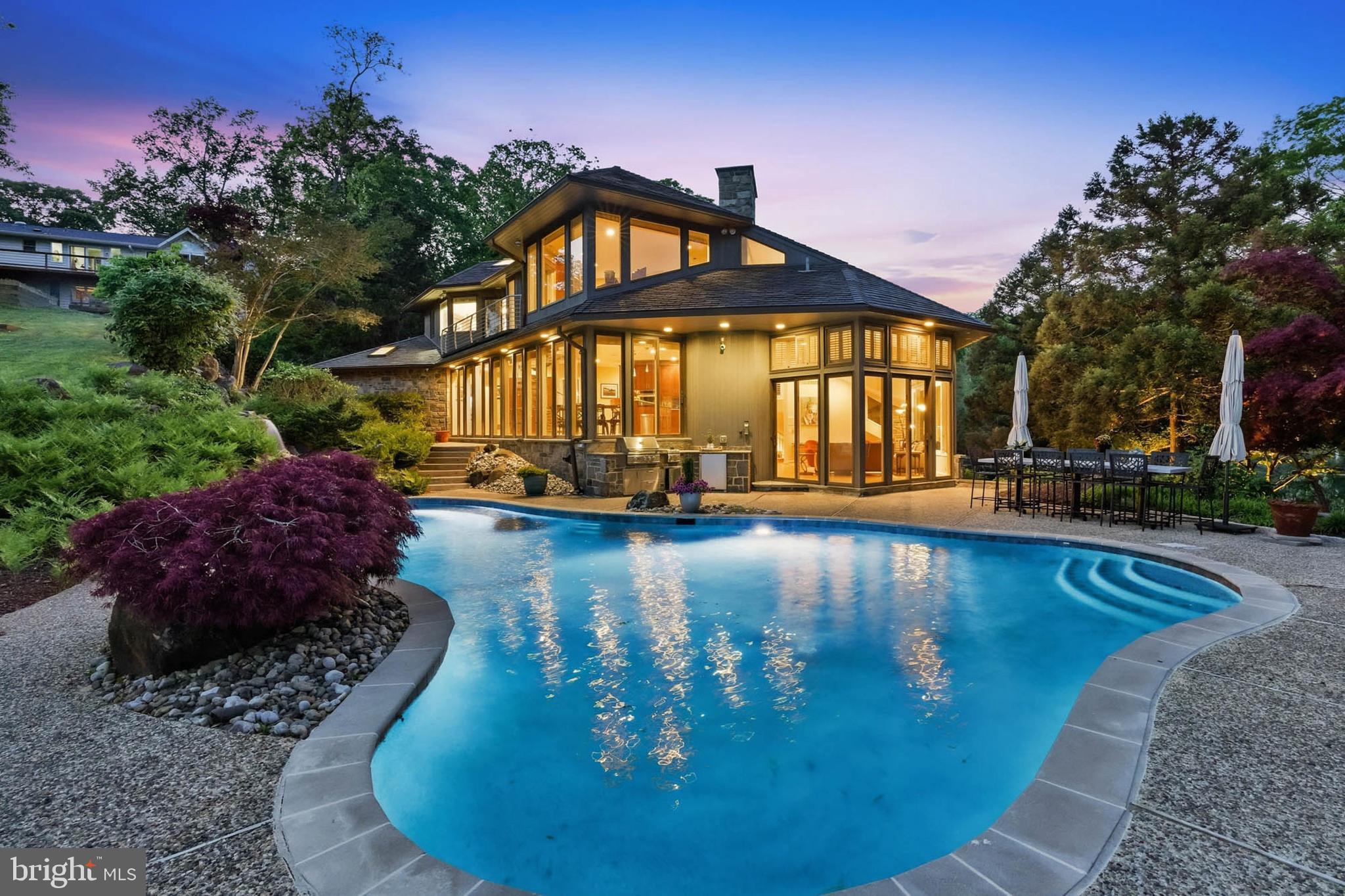 SELLER WILL LOOK AT AND CONSIDER OTHER OFFERS.  72 HOUR KICK OUT CLAUSE IN PLACE.  REDUCED $250K FOR THE MOTIVATED BUYER TO ENJOY THEIR PRIVATE RETREAT IN TIME FOR A FABULOUS SUMMER STAYCATION!!  Discover your own private waterfront paradise in this exceptional 6-bedroom, 5.5-bathroom home that feels like a year-round luxury resort.

From the moment you arrive, expansive water views greet you from every room, inviting natural light and serenity indoors and out. The home's prime private lot faces west, offering breathtaking sunsets that paint the sky in vibrant hues—perfect for unwinding after a day on the water.

Step outside to an entertainer’s dream backyard: a saltwater heated pool with cascading waterfalls for refreshing swims, a relaxing hot tub tucked into beautiful landscaping and hardscape, and a full outside kitchen right by the pool for effortless poolside gatherings. A sandy beach invites barefoot strolls, while the wildlife—playful ducks and turtles—adds a touch of natural charm to your daily life.

At the water’s edge, your private pier features 8+ MLW depth and multiple slips accommodating four or more boats, complete with electricity and water. Whether you’re boating, fishing, or simply enjoying the views, this setup delivers unmatched convenience and fun.

Inside, the chef’s kitchen impresses with premium appliances including a double oven, induction stove, trash compactor, built-in microwave, warming tray, and abundant cabinetry for all your storage needs. Two dramatic floor-to-ceiling wood-burning fireplaces create cozy, inviting focal points for family nights or elegant entertaining.

With so many thoughtful features and endless opportunities for waterfront living, this home offers a lifestyle that’s hard to find and impossible to forget. It’s truly a must-see property—schedule your private showing today and imagine making this dream your reality.
