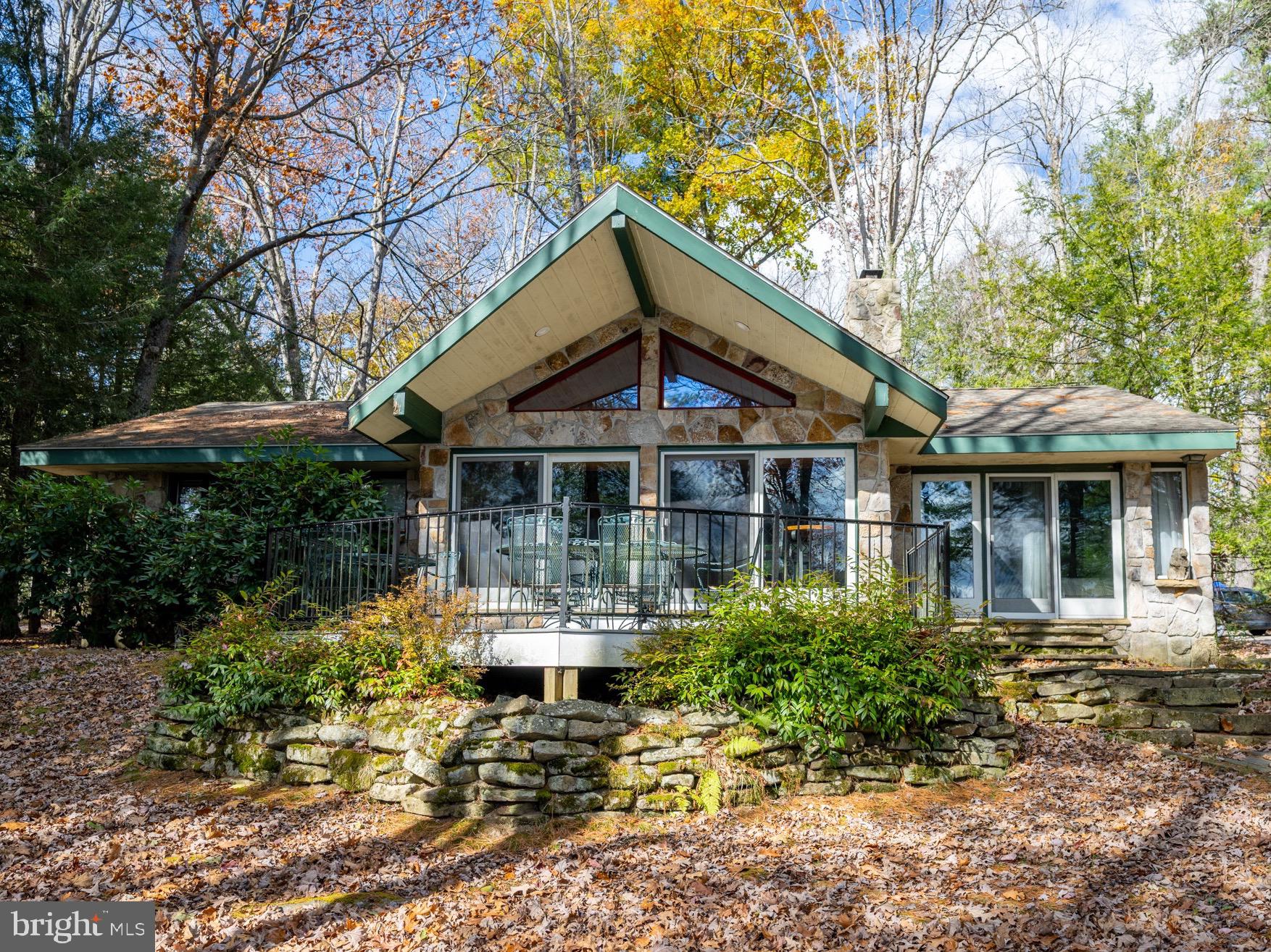 Lakefront Stone Cottage on Deep Creek Lake! Discover the perfect blend of classic charm and modern comfort in this updated 3-bedroom, 2-bath lakefront stone cottage nestled along the serene shores of Deep Creek Lake. Set on a level, open lakefront lot with deep water access and a private boat dock, this home offers an ideal retreat for lake lovers and outdoor enthusiasts alike. Great history abounds as this house was originally built by the Harvey family when the peninsula parcel was divided.
Step inside to a spacious family room featuring a massive stone fireplace and a wall of windows framing breathtaking lake views that opens to a lakeside deck. The open layout is complemented by new luxury vinyl tile and ceramic tile flooring throughout, creating a fresh, cohesive feel. The one-story level floor plan makes access to the home and navigation inside a breeze!
The modern kitchen is designed for both style and function, showcasing stainless steel appliances, a tiled backsplash, and ample cabinetry for all your culinary needs. The primary suite overlooks the lake and opens directly onto the lakeside porch, perfect for morning coffee or evening sunsets. The private bath is generously sized and features a double vanity and modern finishes. Two additional bedrooms share a well-appointed full bathroom, providing comfort for family and guests.
Thoughtful details like the entryway bench with hooks and cubbies add convenience and character - and also including heated tile bathroom floors. Outside, walk down the fieldstone path and enjoy the beautifully crafted stone patio and fire pit just steps from the water’s edge—ideal for entertaining or relaxing by the fire. A stacked stone-built lakefront retaining wall enhances the property’s timeless appeal and stability.
This offering includes two additional parcels: the lakefront buy-down lot and a separate back lot with public sewer access, providing potential for an additional full-size single-family residence.
Located just minutes from Deep Creek Lake State Park, marinas, restaurants, and the Wisp Resort ski area, this property offers an unbeatable combination of tranquility and accessibility. This home is a well established VRBO rental. 
Whether you’re seeking a year-round residence, a vacation getaway, or an investment opportunity, this Deep Creek Lakefront stone cottage is a rare find that combines rustic elegance, modern updates, and premium lakefront living. The same owners for 34 years!