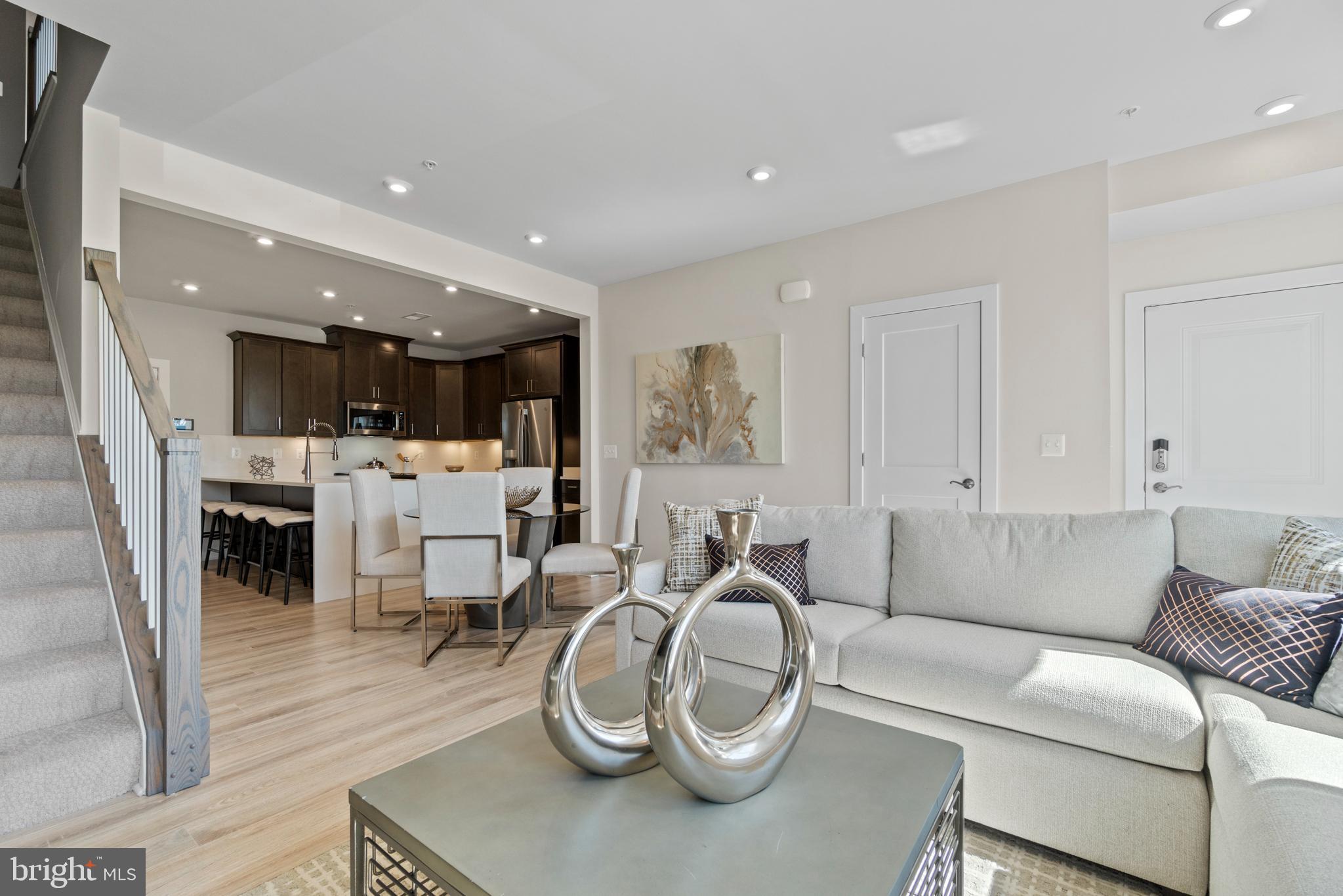 Brand New Stanley Martin 2-level Garage Condo at Ashburn Station walking distance to the Silver Line metro. The open-concept design of The Tessa allows for ease of living and entertaining from the kitchen to the main family room whether that means a casual dinner on the couch or hosting happy hour with friends. The front of the condo has three large windows allowing for natural light to flood the space, making it feel even more spacious and open. The family room is large enough for a 5-8 person sectional and is connected to the dining space and kitchen. For a 3-bedroom condo, the kitchen is built to impress. The quartz countertop peninsula provides seating for 5 and plenty of space to lay out meals. The oversized primary suite on the second floor is big enough to make you feel like you’re in a single-family home. It has an en-suite bathroom, double vanities, two walk-in closets, and a private water closet. Two other bedrooms with a full hall bathroom is perfect for out-of-town guests or a work-from-home space! Photos shown are from a similar Tessa floor plan. 
Design selections have not yet been chosen for this home. The current price reflects Base Price and Structural Options, the final price will increase once a design package is added. Contact the Neighborhood Sales Manager or stop by today for more information. Contact us today to schedule a tour!  Currently selling offsite at our Ashbrook Place neighborhood near one Loudoun located at 20306 Newfoundland Sq, Ashburn, VA

Ashburn Station within walking distance of the silver line Metro in Northern Virginia. Enjoy amenities dispersed throughout this new neighborhood including a gaming lawn, 2 workout stations, a playground, and multiple community parks featuring greenspace, firepit, grilling station, and outdoor seating. This location is a short walk or quick drive to the many shopping, dining and entertainment options throughout central Loudoun County.

Ashburn Station is ideal for residents who want to work and play close to home. Contact us today to schedule a tour!