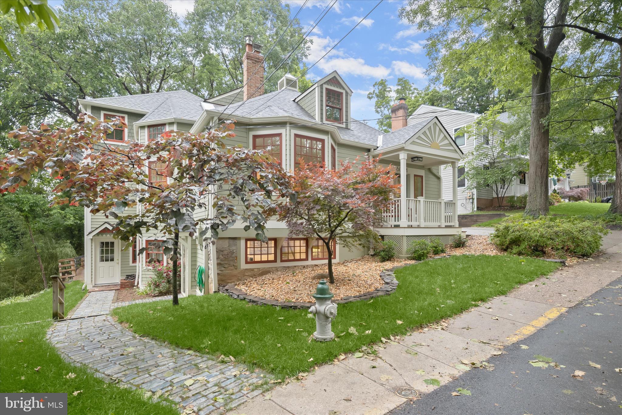 Nestled in the charming Town of Glen Echo, this expanded Victorian-inspired Cape offers a unique blend of character, space, and convenience. Originally built in 1905, thoughtfully expanded in 1980, and extensively renovated inside and out, this 5 bedroom, 4 bath home sits on a 5,224 sq. ft. lot bordering National Park Service land and overlooking the C & O Canal. A complete exterior renovation, completed in 2022, enhanced the home’s timeless appeal with the addition of a welcoming covered front porch with a painted sunburst pattern above, expansive wraparound deck, Hardie-plank siding, architectural shingle roof, skylights, triple-pane windows and a shed.

Elegant architectural details include a gracious living room with fireplace, walk-in bay window, and 9-foot ceilings, along with a distinctive octagonal dining room at the center of the home. The spacious family room and Chef’s kitchen featuring Blue Pearl granite countertops, cherry cabinetry, generous built-ins, and an additional fireplace, creating an inviting gathering space. The upper-level primary suite offers a walk-in closet and dual-sink bath, while four additional bedrooms provide flexible options for guest rooms, offices, or hobbies. Original crown moldings, window trim, and maple floors have been beautifully preserved, blending historic charm with modern comfort.

A private walk-out lower level provides approximately 1,400 sq. ft. of flexible living space with its own exterior entrance and lockable separation from the main residence. Ideal for guests, a home office, studio, or multigenerational living, the space includes living and sleeping areas, a galley kitchen, walk in bay window dining nook, ample storage, and canal views. A separate mudroom and utility area with sink offer additional potential for a wine cellar, workshop, or hobby space.
. 
Enjoy seasonal river views, natural surroundings, and a truly special neighborhood setting with easy access to Glen Echo Park, the C&O Canal, shops, trails and convenient commuter routes to Bethesda, Washington DC, and Northern Virginia. Neighbors gather at the Town Hall for holidays, picnics, and community events, creating a warm and welcoming small-town atmosphere. Bannockburn, Pyle and Whitman school cluster.