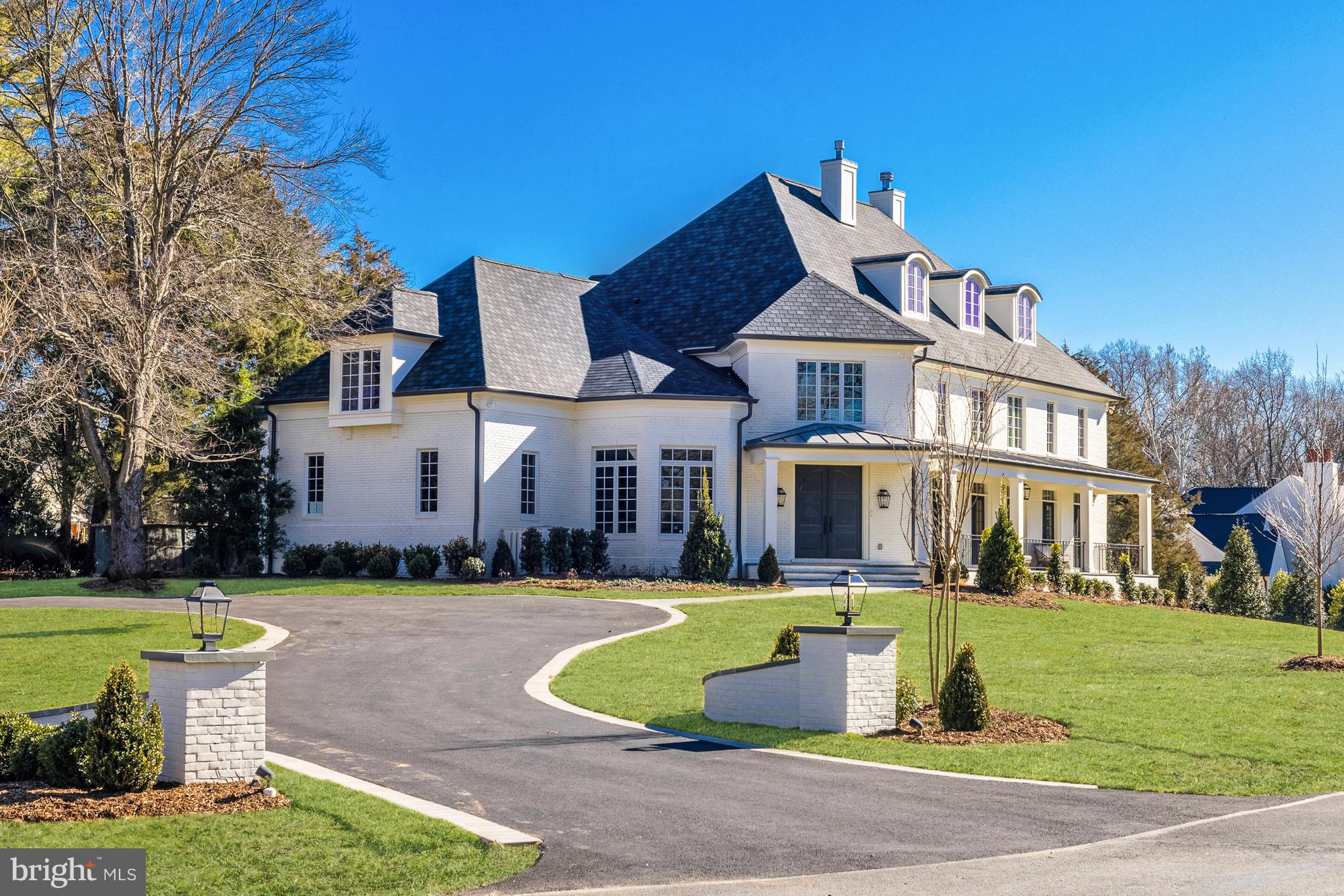 Nestled on a beautiful one-acre estate lot in close-in McLean, 6511 W Langley Lane stands as a testament that the architectural grandeur of a home can be preserved, even as it undergoes a complete transformation into a refined and sophisticated residence for today's standards. Meticulously renovated, this residence is an incredible collaboration of timeless elegance by premier builder Brush Arbor, in partnership with Wellhouse Interior Design and MV Architects. And it is one that most certainly will be enjoyed for generations to come.
 
Spanning approximately 11,600 square feet across four levels with multiple covered verandas and a large circular drive, this estate showcases a seamless fusion of functionality and design. The lush, flat, south-facing rear lawn provides inspired potential for customization with options for al fresco dining spaces, pool, spa, sport court, putting green, water features, extensive plantings and gardens, fire pit or more. Included in the list price is a significant allowance towards the customization of the outdoor space. Call the listing agent for more details on the allowance. 
 
Boasting 7 bedrooms (5 on the main bedroom level), 8 full baths and 2 half baths, the estate offers a host of amenities. Every detail has been curated for the discerning eye, from bespoke millwork and finishes such as stunning marbles, the finest of lighting, hardware and cabinetry selections. Further interior comforts include an elevator, stone wine cellar, front and back staircases, lower level kitchenette, multiple fireplaces and laundries and more.
 
From the grand foyer, a captivating welcome unfolds with soaring 24 and 18 foot ceilings. Bedrosian black and white tiled floors lead to a grand staircase and adjoining library with custom floor-to-ceiling bookcases and library ladder. The formal dining and living rooms feature a fireplace with stunning Marble surround, while large casement windows and multiple sets of French doors anchor all the primary spaces, yielding bucolic views.
 
The kitchen is outfitted with extensive walk-in pantry space and top-of-the-line appliance package including paneled, integrated dishwashers, fridge and freezer columns and refrigerator and microwave drawers, Wolf 60” dual fuel range and Miele built-in cappuccino machine. A vast family room with the second of four fireplaces, seamlessly connects to the kitchen, opens onto the main level's patio, screened porch, and terrace. Also on the main level, the attached three car garage, family powder room and family entrances are ingeniously equipped with custom cubbies, a dog wash, and the first of four laundries.
 
Ascend to the second level to discover five en-suite bedrooms, including the beautiful primary suite. This retreat features a sitting room with fireplace, two walk-in closets, laundry, specialty trim, and a spa-like bath. Secondary bedrooms echo the pattern of discerning finishes, such as custom built-ins and all with new ensuite baths and walk-in closets.
 
The large third level, with its vaulted ceilings, and large dormer windows includes a wet bar and a full bath. The versatility of the space is remarkable-perhaps a bunk room and a golf-simulator, home office or more. Don’t miss the delightful fourth level ancillary space accessed through a hidden door.
 
The daylight walk-out lower level offers an expansive recreation room, office, exercise room, stone wine cellar and second kitchen, as well as two full baths and one with a steam shower. Adjacent to the recreation room is a covered terrace/loggia with fireplace and extensive under-patio concrete walled storage.
 
6511 W Langley Ln presents an exclusive opportunity to customize an exterior escape, paired with the best of interior construction and design, offering the utmost privacy and a lifestyle of unrivaled luxury and sophistication.