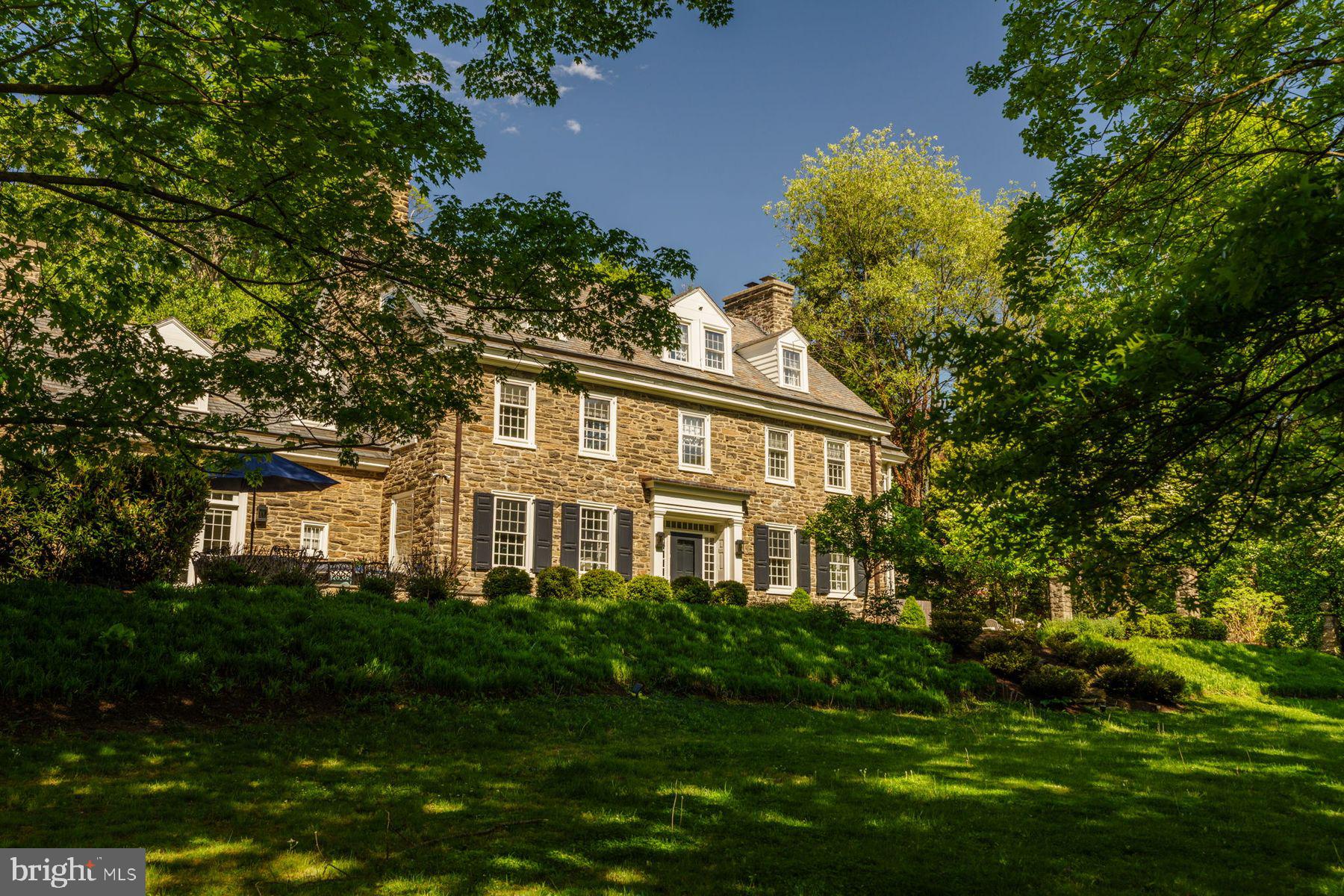 Fall in love with this classic stone colonial that has been lovingly updated for today's buyer. The charm and character of the original home shine through but the overall feeling is one of crispness and light. Accessed from the stylish center hall is a striking living room with its custom fireplace. An adjacent sunroom/family room is adorned with three walls of windows, overlooking attractive garden views. The large dining room is anchored by a stunning fireplace and presents the perfect space for entertaining. The kitchen, which features granite countertops, leads to a separate laundry room and mud room.

Upstairs the primary bedroom is accompanied by a large bath featuring marble floors, double vanity, a jetted tub and shower. A second floor porch beckons invitingly. Two additional bedrooms, a hall bath, and an office/study complete this floor, while two large bedrooms and a pair of nicely updated baths round out the top floor. The house comes with five-zone heating, four-zone cooling, and considerable storage space as well as a large finished basement perfect for additional entertaining space. 

It's an easy walk to the park, SEPTA’s Chestnut Hill West line, local schools and a multitude of shops and restaurants, but you may be reluctant to leave this home and its surrounding grounds. The beautifully designed backyard features an outdoor kitchen and fireplace overlooking a two-tiered lawn, creating an exceptional setting for entertaining and relaxed outdoor living.
