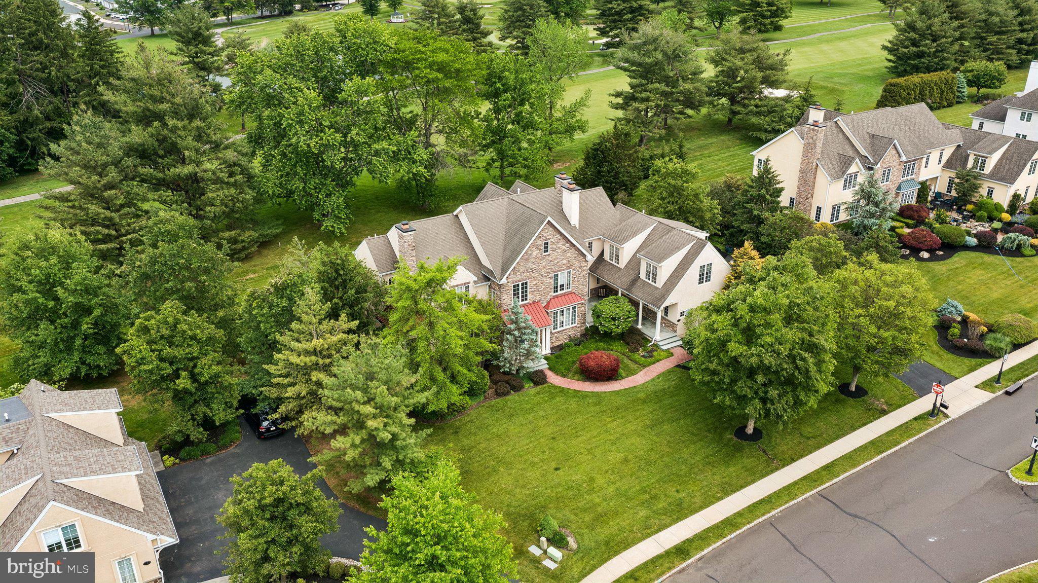 Welcome to an exceptional luxury estate nestled within the prestigious Poet's Walk community. Backing to a picturesque golf course with pond views and a stunning water fountain, this magnificent residence offers approximately 8,700 sq. ft of exquisitely designed living space.  A stacked stone and stucco façade, bluestone front and side entry patios, and a three-car garage create a commanding first impression. Upon entering, you are greeted by soaring ceilings, extensive millwork, triple crown molding, and an abundance of natural sunlight that fills every room through oversized windows enhanced with UV protective film. Designed for both grand-scale entertaining and comfortable everyday living, the homes thoughtfully designed open-concept floor plan seamlessly blends sophisticated formal spaces with inviting casual living areas. The elegant formal living room serves as a refined gathering space, featuring a beautiful fireplace and direct access to the expansive bluestone patio. The formal dining room provides the perfect setting for memorable dinners offering picturesque views of the private grounds. Adding to the home's exceptional appeal, the Conservatory showcases a third fireplace and walls of oversized windows and a private access patio. At the heart of the home lies a gourmet chef's kitchen, thoughtfully designed with granite countertops, an oversized center island, custom cabinetry, anchored by two elegant butler stations adorned with exquisite glass-front cabinetry and a wine cooler. Just beyond, the sun-drenched breakfast room offers a warm and inviting setting for casual dining while enjoying views of the surrounding grounds. A striking French-inspired multi-pane glass partition creates a sophisticated architectural separation between the breakfast room and the spectacular two-story family room, providing both distinction and openness while allowing natural light to cascade throughout the home's main living spaces. This elegant design element enhances the home's timeless character and refined aesthetic while preserving the seamless flow desired for modern living. The dramatic family room is a true showpiece, featuring soaring ceilings, impressive arched windows, rich architectural details, surround sound, and a beautiful fireplace that serves as its focal point. An upper-level overlook balcony further accentuates the room's grand scale and open-concept design. Multiple access points lead to the expansive rear Trex deck from both the breakfast room and family room, creating effortless indoor-outdoor living. An electric awning provides shade and comfort while overlooking the breathtaking golf course, pond, and fountain views. Ascending either the grand front staircase or the secondary rear staircase, the upper level continues to impress with soaring ceilings, abundant natural light, and thoughtfully designed accommodations that balance luxury with everyday comfort. The owner's suite features a spacious sitting area, an oversized walk-in closet, and a spa-inspired primary bath. Four additional bedrooms and multiple well-appointed bathrooms provide ample space for family and guests. Among them, an expansive ensuite is ideally suited for multigenerational living, or au pair accommodations. The finished walkout lower level is an entertainer's dream, offering an exceptional extension of the home's living and recreational spaces. Distinguished by soaring ceilings this impressive retreat features a wet bar, surround sound system, and expansive open areas. Adding to its appeal, the lower level also includes a private bedroom combined with an adjacent full bathroom. Additional premium features include four-zone HVAC systems, a whole-home piped music system. The home's floor plan, generous room sizes, dual staircases, and flexible living spaces provide a level of functionality rarely found in today's market.  This is more than a home—it is a statement of luxury living at its finest.
