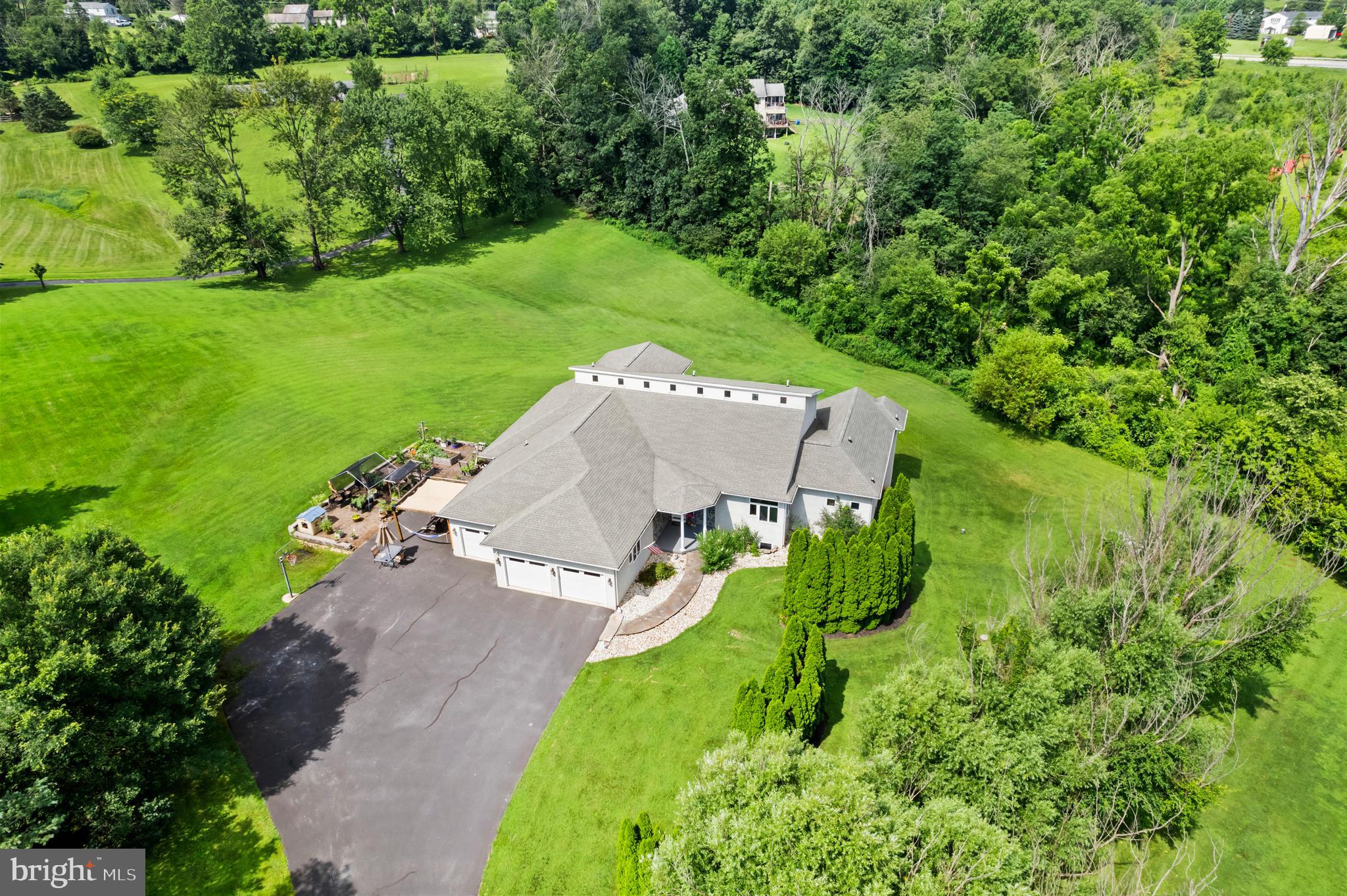 Custom Architectural Masterpiece on 2.37 Private Acres – Versatile Living & Expansive Grounds
This custom 2001 architectural masterpiece by renowned builder Donald Heimbach offers sophisticated modern design on a rare, private 2.37-acre flag-lot estate — perfectly balancing peaceful seclusion with exceptional versatility. Offering 5 bedrooms (and room for more), 3-1/2 bathrooms, and 4,502 sq ft of thoughtfully designed space, it delivers an open, flowing layout that is exceptionally versatile for extended families, multigenerational households, remote workers, and anyone seeking room to live, work, and entertain.
The dramatic main level showcases impressive architectural details and custom craftsmanship with soaring 20-ft vaulted ceilings, abundant natural light, a striking circular steel staircase leading to a large loft with an outdoor balcony, and a wall of windows that opens to an expansive 1,000+ sq ft rear deck overlooking the private yard. Enjoy an open-concept kitchen and living area ideal for entertaining, a main-floor primary suite with deck access and spa-like bath, a dedicated multi-desk work-from-home space, and convenient in-law/guest quarters with private entrance and full bath.
The finished daylight walkout lower level provides exceptional flexibility as a private guest suite, teen suite, or additional versatile living and entertainment area. It includes three large bedrooms, a full bath with a tiled walk-in shower, a kitchenette, and a generous recreation/living space — all bathed in natural light and functioning as a self-contained retreat.
Superior construction shines through with an engineered I-joist floor system, 200-amp electrical service, gas HVAC, and on-demand hot water. Outside, mature trees ensure privacy, while the long macadam driveway offers ample parking for guests or events. Additional highlights include garden areas, room to roam, and abundant wildlife.
This one-of-a-kind property delivers quality craftsmanship, versatile living options, and peaceful acreage living in a highly accessible location just minutes from Routes 100 and 422 in the heart of the Reading-Allentown-Philadelphia triangle. Schedule your private tour today!
