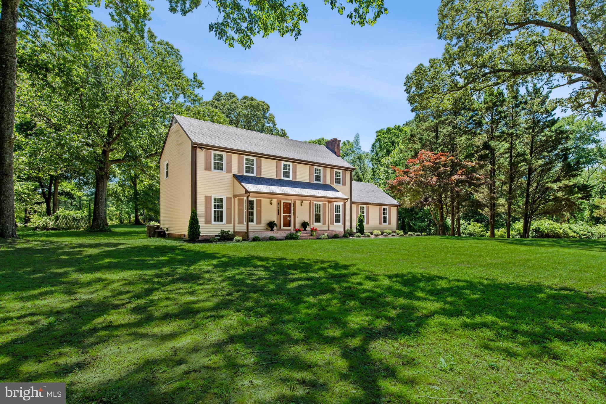 Set beyond a welcoming covered brick front porch, this exquisite four-bedroom, two-and-a-half-bath colonial, is a rare blend of timeless character and elevated modern living, beautifully situated on three picturesque acres. From the moment you arrive, the home’s charm is undeniable from the original architectural details thoughtfully preserved and paired with impeccable renovations executed with an exceptional eye for design. Inside, a classic colonial layout unfolds into large, light-filled rooms that feel both refined and inviting. The stunning family room is a true gathering space, anchored by a dramatic brick wall fireplace and crowned with a gorgeous wood-beamed ceiling. French doors lead seamlessly into a sun-drenched sunroom with soaring cathedral ceilings and a striking Palladian window, offering panoramic views of the surrounding property. Additional French doors in the sunroom open to the backyard, creating an effortless connection to the outdoors. At the heart of the home, the kitchen is nothing short of spectacular, a true showstopper. Navy and white cabinetry, 42-inch upper cabinets, gleaming brass hardware, stainless steel appliances, quartz countertops and a classic subway tile backsplash create a space that is both stylish and timeless. There is ample room for a breakfast table or charming built-in corner banquette, making it as functional as it is beautiful. Adjacent to the kitchen, the formal dining room features elegant chair rail and crown molding and opens through natural wood French doors to a flexible living space ideal for a den, study, library, or formal living room. Upstairs, four well-appointed bedrooms provide comfort and privacy. Three generously sized bedrooms feature ceiling fans and bright, sunny windows and share a beautifully renovated hall bath.  The primary suite is the crown jewel, an extraordinary retreat highlighted by a captivating brick fireplace that adds warmth and character rarely found today. A thoughtfully designed dressing area includes a large vanity with abundant storage and counter space, separated from the shower and toilet room for added convenience, along with a spacious walk-in closet. Additional highlights include main-level laundry, an oversized driveway, a two-car garage with an impressive overhead storage loft accessed by fixed stairs, as well as a separate storage building. Mature landscaping frames the property, enhancing the natural beauty and sense of privacy. Recently renovated while honoring its original soul, this remarkable home offers timeless charm, luxurious comfort, and a setting that feels both gracious and serene a truly special offering that cannot be replicated. Recent Renovations include: Full Kitchen remodel (cabinetry, countertops, appliances, flooring and fixtures). New Roof. New flooring throughout majority of house. New Windows. Fully repainted. New landscaping. All Bathrooms fully remodeled New lighting throughout. All crawlspace insulation replaced. New vapor barrier installed that runs up foundation block. Water softening / treatment system installed (owned).