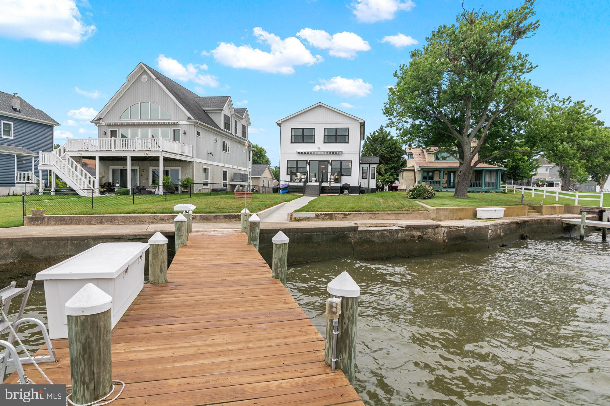 No expense was spared in the complete transformation of this extraordinary waterfront residence!  Buyers will appreciate the luxury features, functionality, and timeless craftsmanship that come together to create a truly one-of-a-kind home.  Thoughtfully designed for both everyday comfort and long-term living, the home offers accessibility and "aging in place" features including a first-floor bedroom and full bath, widened doorways, barrier-free bathrooms, wheelchair-friendly kitchen design, and future-ready accommodations for additional accessibility upgrades.  Every detail was carefully considered—from the maintenance-free exterior materials and Anderson 400 Series Low-E windows strategically positioned to maximize breathtaking water views, to the custom cabinetry, imported Italian tile, Dekton countertops, and stunning quartzite finishes. The gourmet kitchen is equipped with GE Café smart appliances, a Zephyr range hood, custom cabinetry with premium storage solutions, and thoughtful features including a hands-free water-saving foot pedal and concealed power outlets.  The home seamlessly blends luxury with cutting-edge technology. App-controlled smart home systems allow remote operation of the lighting, motorized shades, HVAC, security, cameras, Yale WiFi lock, heated bathroom floors, water heater, and major appliances from virtually anywhere in the world. Lutron RadioRA 3 lighting creates customizable scenes throughout the home, while designer lighting, under-cabinet illumination, and a dramatic porcelain fireplace wall provide an inviting atmosphere day and night.  The spa-inspired bathrooms feature heated porcelain floors, Toto Washlet bidets, custom vanities, ultra-quiet automatic moisture-sensing ventilation, and elegant wet-room designs that are both beautiful and exceptionally easy to maintain.  Outdoor living is equally impressive. Enjoy spectacular waterfront sunsets from the maintenance-free deck beneath the motorized Sunsetter awning or head to the private dock, complete with electricity, water, fish-cleaning station, dock box, Marina Mate system, and a 10,000-pound Hi-Tide boat lift.  Additional thoughtful upgrades include spray foam insulation, gutter guards, an insulated attic, powered workshop shed, raised garden beds, multiple exterior hose bibs with interior shutoffs, and countless energy-efficient enhancements throughout.  Adding to the home's unique character, the current owners thoughtfully preserved pieces of its rich history, incorporating original hardware, historical photographs, and even the property's original 1920s rental agreement into the renovation as a tribute to the home's remarkable legacy. Furniture, décor, kitchenware, tools, and numerous additional items are available for purchase separately, offering the opportunity to enjoy this exceptional waterfront retreat exactly as it has been curated.  A comprehensive list of custom upgrades, smart home features, specialty finishes, and construction details is available upon request. This is a home that simply must be experienced in person to fully appreciate the extraordinary level of planning, craftsmanship, and investment that went into every detail.