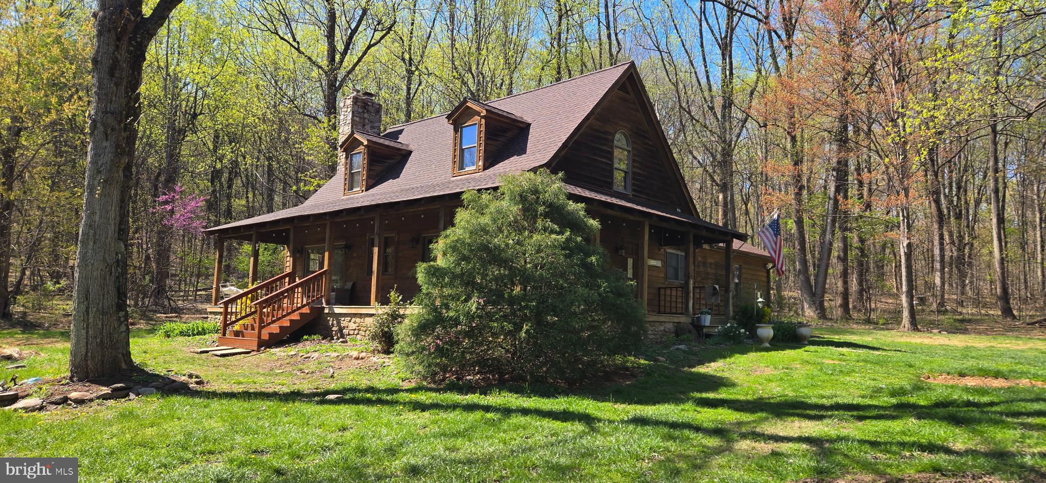 *** 52,000 PRICE REDUCTION ***Experience a "refreshingly real" escape in this stunningly refurbished log-and-stone lodge, situated on nearly 18 private acres backing to Short Hill Mountain. This turnkey residence features over $74,000 in recent upgrades, including a brand-new roof, updated HVAC, fresh paint, and new carpet throughout. A newly constructed $37,500 private road ensures seamless access to your secluded forest sanctuary.
The interior boasts soaring two-story ceilings and a massive floor-to-ceiling stone fireplace that serves as the home’s focal point. The open layout transitions from a warm country kitchen to a spacious dining area and living room, perfect for entertaining. With primary suites located on both the main and upper levels, the floor plan offers exceptional flexibility. Outside, a wrap-around porch provides sweeping mountain and forest views, while multiple outbuildings—including a run-in shed and tool shed—add functional value. Located just 7 minutes from downtown Lovettsville and 10 minutes from the MARC commuter rail, this property balances absolute privacy with modern convenience.