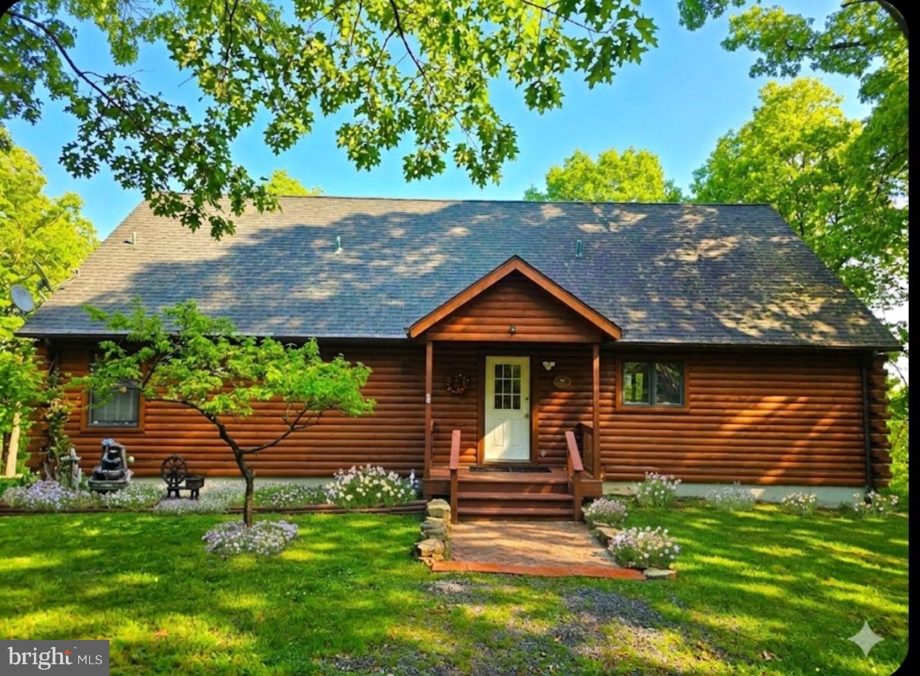 Experience true mountain living in this stunning log home situated on nearly three acres of private, mostly flat land with breathtaking views. Nestled in a serene, wooded location, this property combines seclusion, natural beauty, and modern convenience. Inside, you'll find an inviting open floor plan ideal for both relaxation and entertaining. The great room and adjoining dining area showcase a striking stone gas fireplace and large windows that capture spectacular mountain vistas. Enjoy sunrises and beautiful scenery from the spacious deck. With 4 bedrooms and 4.5 baths, there’s ample room for family and guests. The finished basement expands your living space, featuring a wood-burning stone fireplace perfect for cozy evenings. The wooded property minimizes outdoor upkeep, letting you spend more time watching local wildlife and soaking up the tranquility. Just minutes from Cacapon State Park, you’ll enjoy easy access to fishing, a swimming beach, golf, playgrounds, and miles of hiking trails. Despite its peaceful setting, the home is conveniently located about 10 miles from downtown Berkeley Springs and 30 minutes from Winchester, VA. Recent updates include fresh paint, new carpeting, LVP flooring, new deck, quartzite countertops, and a new dishwasher and dryer. If you’re seeking peace, scenic surroundings, and a retreat-like atmosphere every day, this home truly has it all.