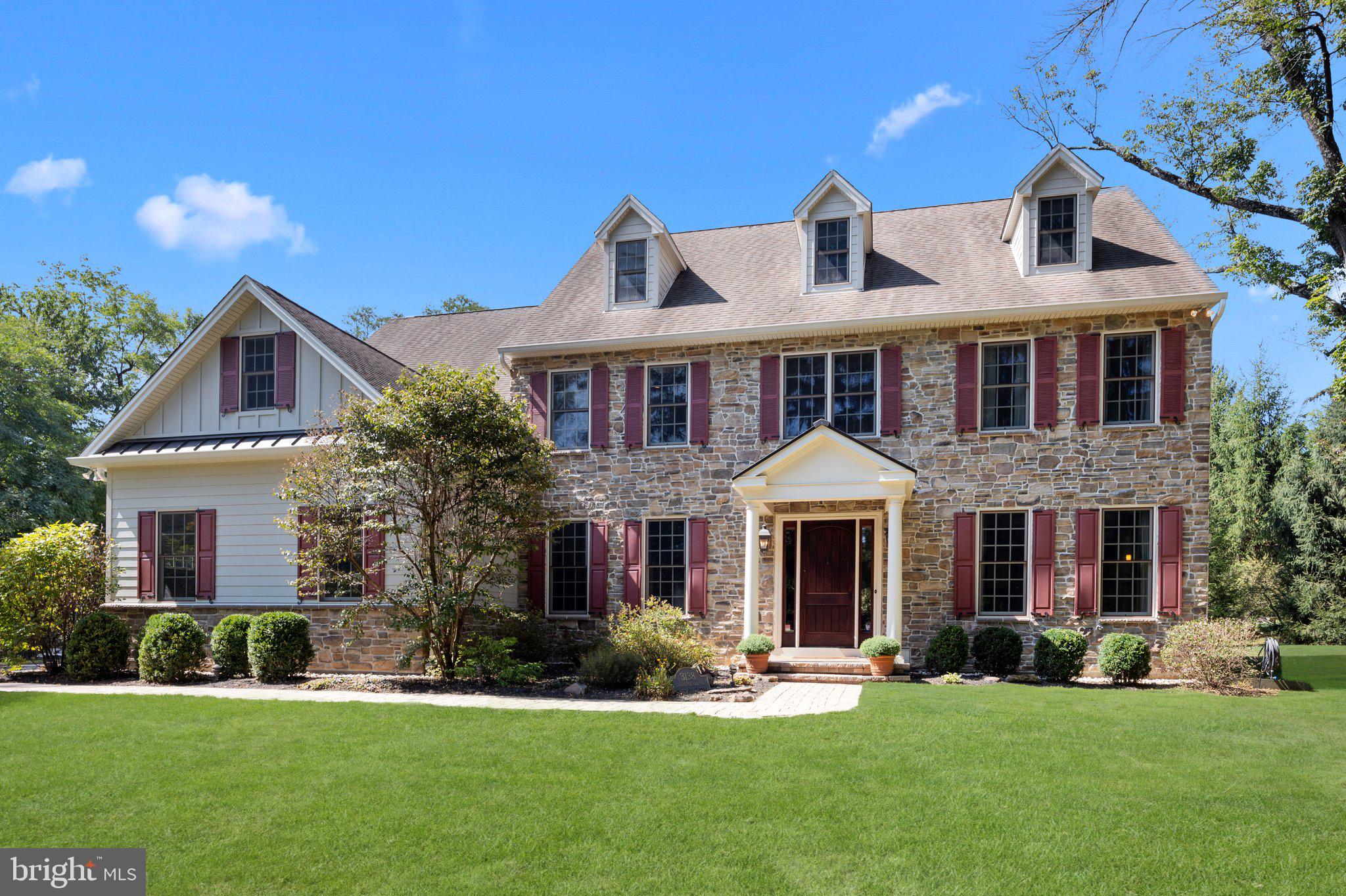 Welcome home to 3138 Church School Road, a picturesque custom colonial nestled on 1.47 serene acres in the bucolic Buckingham Township of Bucks County. This exquisite 4 bedroom, 3.2 bath home is designed for sophisticated entertaining with meticulous craftsmanship and timeless beauty throughout. From the covered front portico, step into the magnificent foyer with soaring 10' ceilings, gleaming cherry hardwood floors, and transom windows flanking the rooms on either side. To the right is an oversized office with pocket doors, an electric fireplace with a wooden mantle, and ample natural light, offering the perfect work-from-home setting. To the left, you will find an elegant dining room with beautiful crown molding, wainscoting, and coffered ceiling with custom lighting to enhance the ambiance of a formal dining experience. Through the dining room, the oversized gourmet chef’s kitchen is a culinary masterpiece featuring top-of-the-line appliances, including a Wolf gas range, a SubZero refrigerator, and a convection microwave. You’ll admire the two-toned double granite countertops, contrasting island, stylish recycled glass backsplash, stunning wood range hood, and abundant custom cabinetry throughout. The oversized center island is the ideal space for meal prep or casual dining. The open floor plan allows for unobstructed views from the kitchen into the impressive great room that features vaulted ceilings and a spectacular wood-burning stone fireplace with a walnut mantle. The maple wood built-in seamlessly tucks away the TV, electronics, and books for an upscale appearance. Natural sunlight pours through the walls of windows and glass doors. Adjacent to the great room is a second, private office or playroom with gorgeous custom built-ins, in close proximity to a convenient powder room. Completing the first level is a spacious mudroom with ample closet space and access to the three-car car garage. Up the turned staircase, you'll find the primary suite and en suite bathroom, with gorgeous tile flooring, a large clawfoot tub, an oversized stall shower, dual vanities, a linen closet and a separate water closet. The expansive walk-in closet with custom organization will suit all of your storage needs. Down the long hallway, two spacious bedrooms with closets share a gorgeous hallway bathroom with tub shower and laundry access. At the end of the hall, a generously sized fourth bedroom features a walk-in closet with built-in shelving, and its own en suite bathroom with tile shower. Two upstairs bedrooms feature spectacular window seats for sunlit leisure reading with ample storage beneath. Through a glass door from the kitchen, make your way to the home's finished lower level, where you will find ample space for entertaining and movie nights, as well as a fitness center, stylish powder room, and an abundance of storage. Four large egress windows bring added natural light. The enchanting backyard oasis with a sprawling paver patio invites you to unwind and relax in style. Enjoy the tranquility of the meticulous grounds, with mature trees and thoughtful landscaping, and endless views of wildlife. Fully equipped with a holiday lighting package to bring joy through every season. Impeccably maintained with updated Hardie plank siding and brand new upstairs air conditioner. The property is located on one of Bucks County's most bucolic country roads, surrounded by quaint farmland, yet in close proximity to modern conveniences like boutiques, restaurants, and routes for commuters. Just off the beaten path between Doylestown, Lahaska, and New Hope, the home is assigned to the award-winning Central Bucks School District. Begin life's next chapter at this exceptional property.