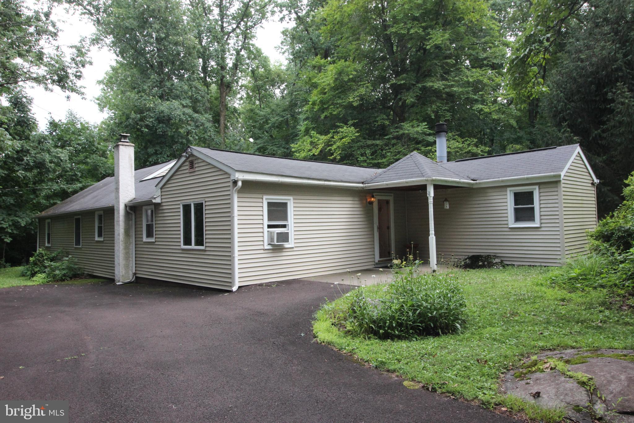 Welcome to this rare find! A single family home that has over an acre and a half. Owner has been here since 1959 and is sad to leave. Three possible 4 bedrooms and one and a half baths.  Nice hardwood floors in the living room and an up step to a reading nook with fireplace.  There is also a side room off of the kitchen that has a pellet stove to diversify the types of heating in the home.  Nice sized main bedroom with two closets that also has a sliding door that overlooks a tree lined yard.  Unique opportunity to own a single family with a nice sized lot for this price.  Great entertainment patio centrally located in the back of the house.  There are two additional sheds and a small one car garage that are easily accessed with a large circular driveway.   Nice private location, but with the convivence of major roads nearby!