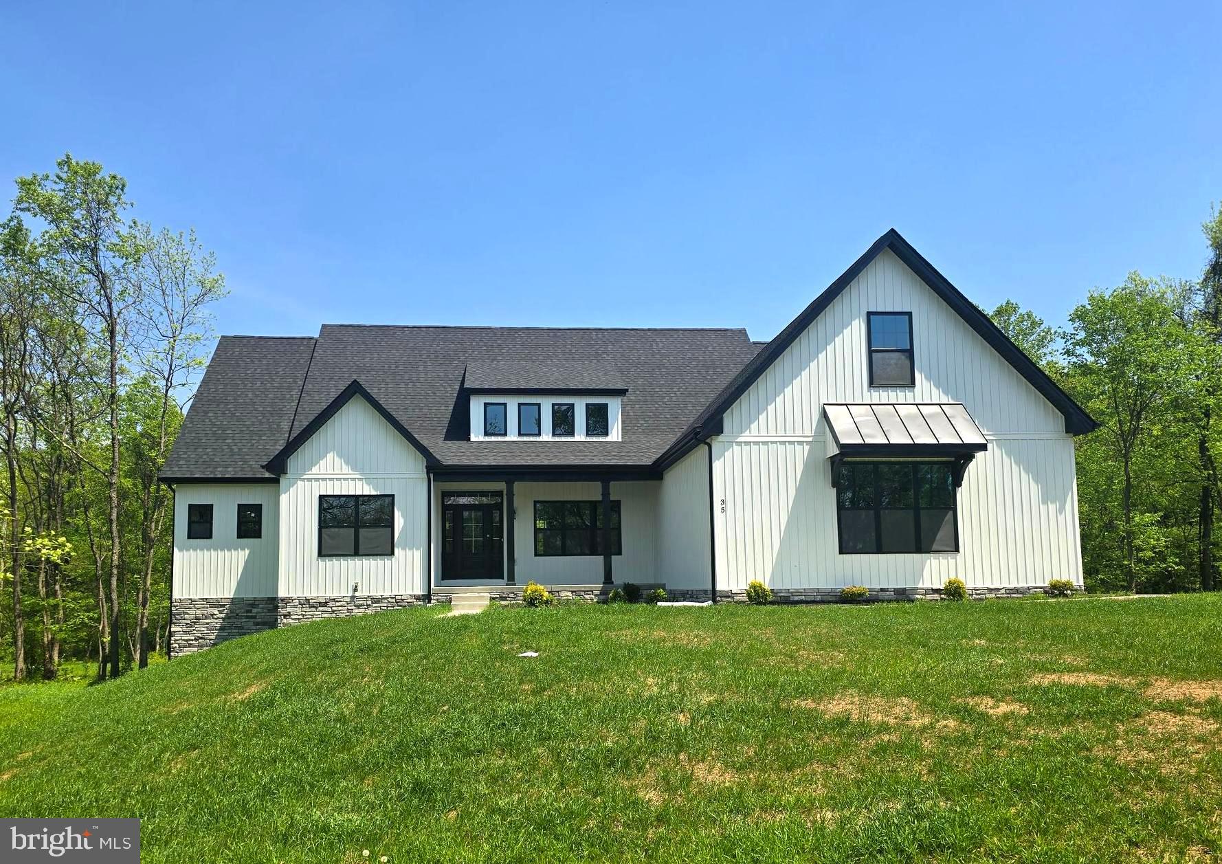 Move-in Ready TODAY! – New Price Just Announced! This stunning new construction home is nestled on a beautifully wooded 2.19± acre lot in an established, highly sought-after neighborhood. Thoughtfully designed to blend seamlessly with the surroundings, this modern farmhouse-style ranch offers 4 spacious bedrooms, 4.5 luxurious baths, and a versatile bonus room over the garage—perfect for a home office, guest suite, or additional bedroom with its own full bath.
Crafted with quality in mind, the home features an upgraded kitchen with quartz countertops, a premium appliance package, soft-close cabinetry, and luxury vinyl plank flooring throughout. Soaring vaulted ceilings add to the open, airy feel, while the full unfinished basement offers endless potential. The beautifully appointed primary bedroom suite includes a spa-like bath and generous closet space—your own private retreat. 
Out back, a peaceful wooded setting offers privacy and frequent visits from local deer—a true touch of nature right outside your door.
Enjoy a secluded country feel while being just minutes from downtown Martinsburg and close to everything the Eastern Panhandle has to offer. You’ll soon discover locals’ favorite farm markets, coffee shops, and bakeries nearby. Plus, you're a short drive to Harpers Ferry, Shepherdstown, and Charles Town—perfect for exploring, dining, and weekend adventures.
Now offered at a new price—this beautifully crafted home is available and waiting for you! 
Photos are of the actual home.