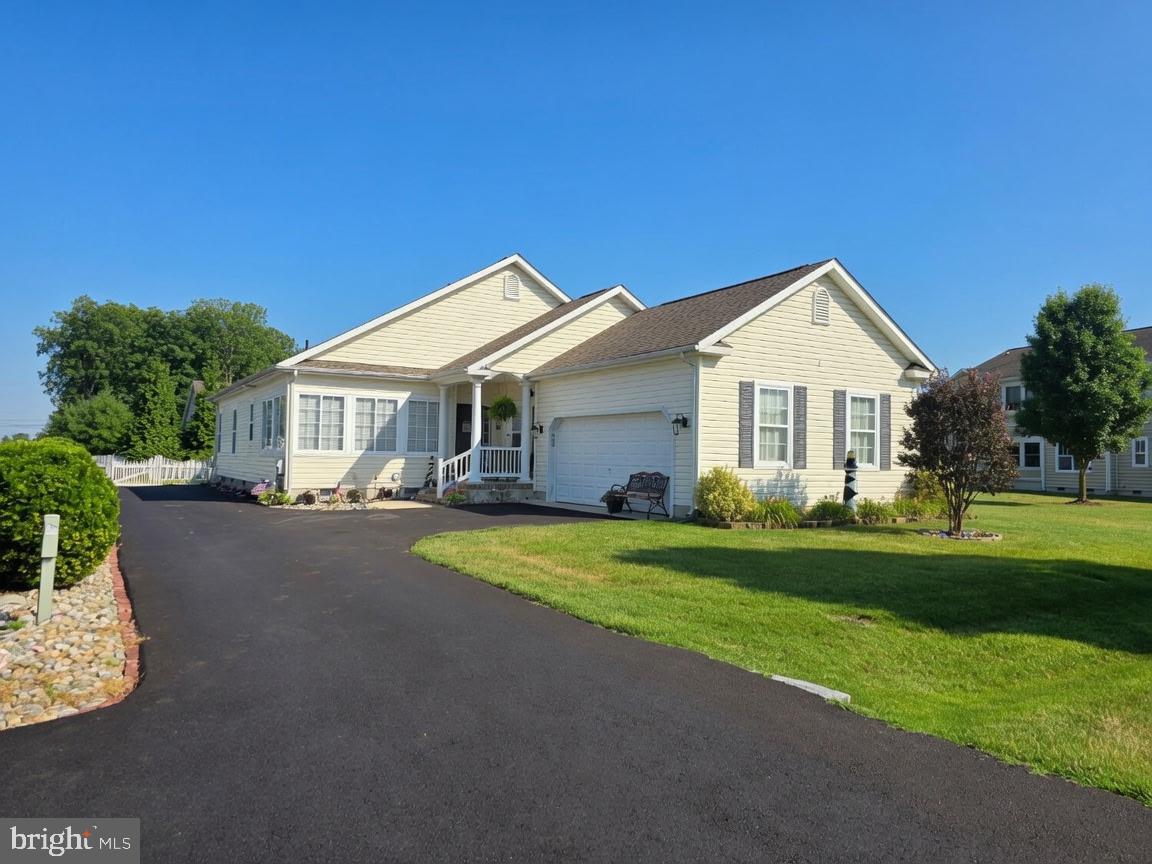 Welcome Home to this spacious 3 bed, 2 bath home right off of rt. 1 , close to resort and local beaches, shopping, restaurants Newer State Of the Art hospital, theaters, bowling and the River walk. Step on up to the front porch and come on in. Walk into an open floor plan with foyer, gleaming hardwood floors, and vaulted cathedral ceilings  Bedrooms are a split floor plan with the primary bedroom having tray ceilings,  2 walk in closets and a primary bath with stall shower and a bath. There are ample sized closets in all the bedrooms.  There is a bonus room that could be used as an office, fitness, T.v./Gaming, playroom or even an extra bedroom. Off of the back of the living room is a sun-room that leads to the screened porch and lush back yard with vinyl picket fencing. The Dining room is open to the kitchen and living room. The kitchen offers plenty of counter space, cabinetry, stainless steel appliances and an island. Right off the kitchen is the laundry with front load machines, large closet/pantry, and leads to the garage area with workspace, shelving and an extra refrigerator. The community is tree lined with gardens, ponds and fountains for gorgeous evening or morning walks.  Come tour this beautiful home today. Live close to the beaches with no sales tax and low property taxes . This home is move in ready with a newer roof with transferable warranty and a complete home warranty, for no worries except where the fish may be biting.