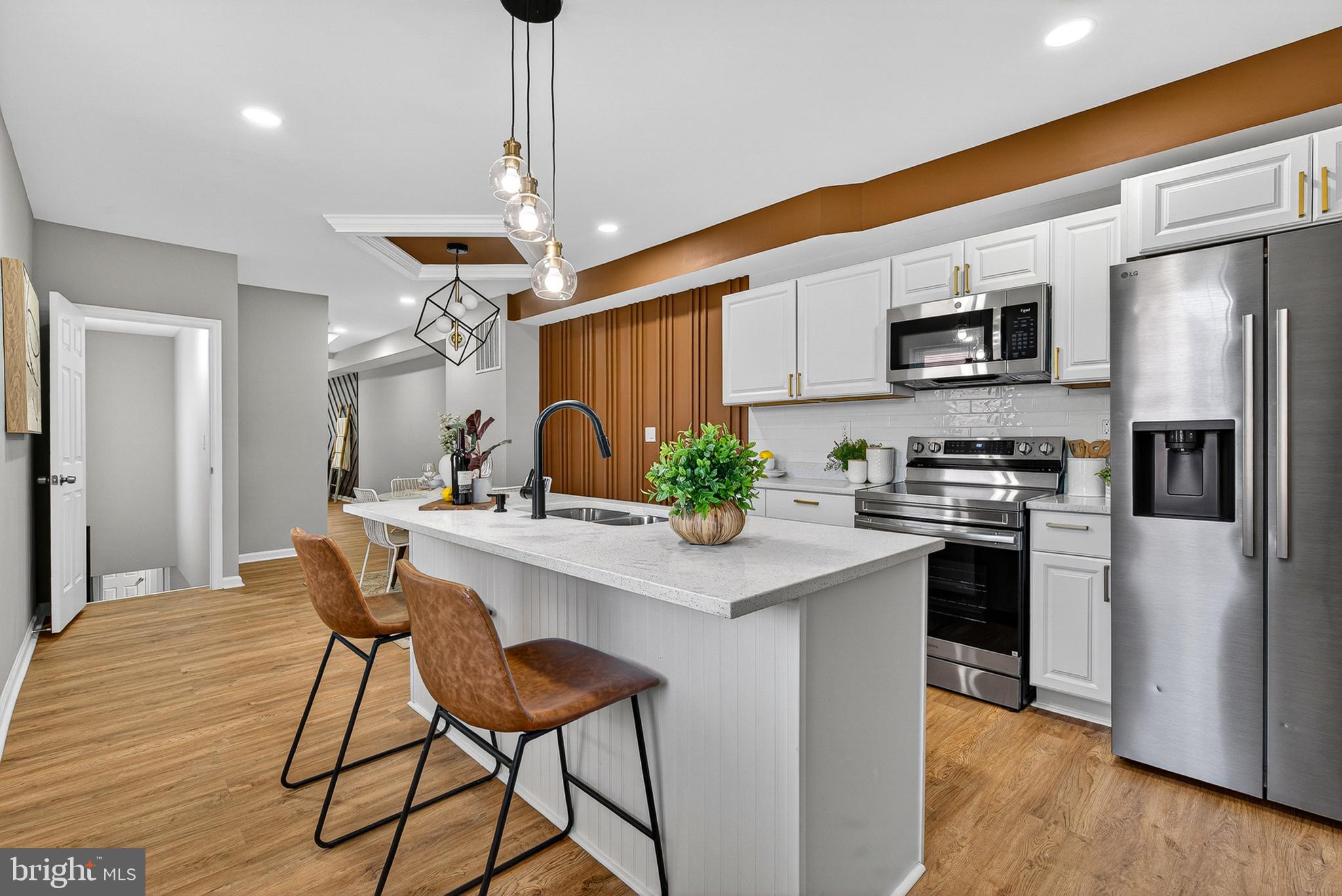 Welcome to this breathtaking newly renovated end-unit townhouse, where sophisticated design meets thoughtful craftsmanship. Spanning four finished levels of luxury, this 5-bedroom, 3.5-bathroom masterpiece offers an unparalleled living experience in the heart of Baltimore.
Step inside to an expansive open-concept floor plan illuminated by recessed lighting and natural light. The living area serves as a true showpiece, featuring a striking custom geometric accent wall and designer tray ceilings with integrated lighting. Rich wide-plank flooring guides you through the seamless transition from the lounge to the dining heart of the home.
The gourmet kitchen is a study in contemporary style, boasting:
Pristine quartz countertops and a sprawling waterfall island with breakfast bar seating. Elegant white cabinetry accented by brushed gold hardware. Full suite of high-end stainless steel appliances.
Unique wood-slat feature walls and designer pendant lighting that add warmth and texture to the space.
The upper levels house the spacious bedrooms, including a sanctuary-like primary suite. The bathrooms are finished with luxury in mind, intricate tile work, and oversized showers with rainfall heads and matte black fixtures. The fully finished basement adds versatile living space, perfect for a home office, gym, or media room. Rare for city living, this property includes a private parking pad at the rear, ensuring you never have to hunt for a space. Fully reimagined from top to bottom. Commanding end-unit presence with classic brick character and modern charcoal accents. Private rear parking pad.
Experience the height of Baltimore luxury. Schedule your private tour of 1448 Aisquith St today!