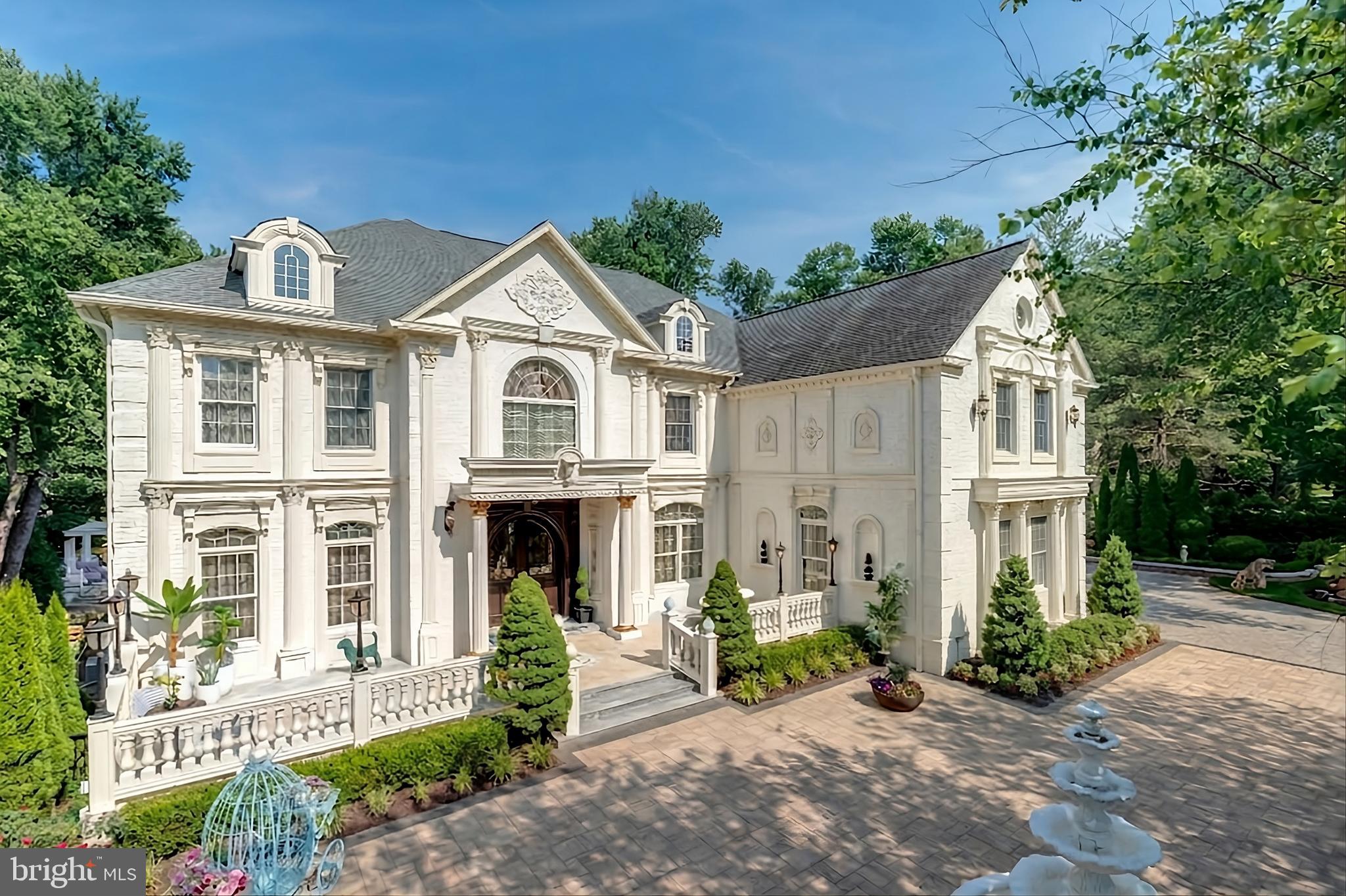 New Price! Motivated Seller. Must see Exquisite artistry, quality craftsmanship, and a touch of glamour combine in this spectacularly appointed 11,000+ sq. ft. manor, set on .89 lush acres. Sited near the Potomac River and moments from the quaint shops and fine dining of Great Falls village, this impressive estate showcases luxurious living at every turn.
A grand marble foyer sets the tone, with lighted recesses, gold-gilded trim, and sweeping views of the home’s richly designed interiors. The formal living and dining rooms feature antique mirrors, crystal chandeliers, intricate ceiling medallions, and decorative hardwood floors with inlaid wool carpeting.
At the heart of the main level, a breathtaking reception area rises two stories, offering an ambiance of elegance and exceptional detail. The richly paneled library is clad in hardwood and features a fossil-stone granite wall with built-ins and fireplace. A coffered-ceiling drawing room includes 11 glass showcases—perfect for art or collectibles. Nearby, a bright music room with bamboo flooring and iron chandelier offers quiet refuge.
The chef-caliber gourmet kitchen impresses with an 8x5 ft. “Louise Blue” granite island and premium appliances. A granite breakfast bar and informal dining area complete the kitchen. Adjacent, a vaulted solarium with bamboo ceiling and French doors opens to expansive decks and lawns, ideal for indoor-outdoor entertaining.
Additional amenities on this level include a paneled elevator, pantry, butler’s pantry with copper sink, mud room, and direct access to the 4-car garage.
Upstairs, the opulent owner’s suite is a private sanctuary that features a tray ceiling, Brazilian cherry flooring with a 100% wool inlay rug, and a cozy sitting area with silk carpet before a marble fireplace and media screen. A morning kitchen offers private refreshment.
The walk-in gallery closet is a boutique experience, with Thomasville cabinetry, center Travertine island, cedar-lined wardrobes, and chandelier-lit tray ceiling. The spa-like primary bath stuns with a central soaking tub before an electric fireplace, dual vanities with 24k gold-gilded sinks, media-screen mirror, and a separate commode room with decorative vanity. Glass-enclosed steam and marble showers, stone seating, and mosaic tilework complete the indulgent space.
Three additional bedroom suites each feature designer bathrooms and walk-in closets. A full laundry room with LG washer/dryer and whirlpool sink completes the upper level.
The lower level embraces a sleek, club-like vibe. Descend via curved staircase with leopard-print carpet to a modern lounge featuring a golf simulator, lighted mosaic bar, billiards area, and expansive rec room—ideal for lively entertaining.
A dramatic home theater, entered through a historic Hotel Washington door flanked by theater masks, includes a custom wool carpet medallion, three-tier leather seating, granite bar, and immersive surround sound.
Also on this level: a 5th bedroom with spa bath, sauna and steam shower; a Tuscan-style wine cellar and tasting room with stone and granite walls; and a utility closet with stacked washer/dryer for guests or staff.
Outdoor living is equally impressive. Walk out to a tiered granite terrace with a summer kitchen, built-in BBQ, and stone fireplace. A generous deck overlooks landscaped lawns and a newly built pool, plus a hot tub with recessed TV and radio—perfect for private relaxation or elegant entertaining.