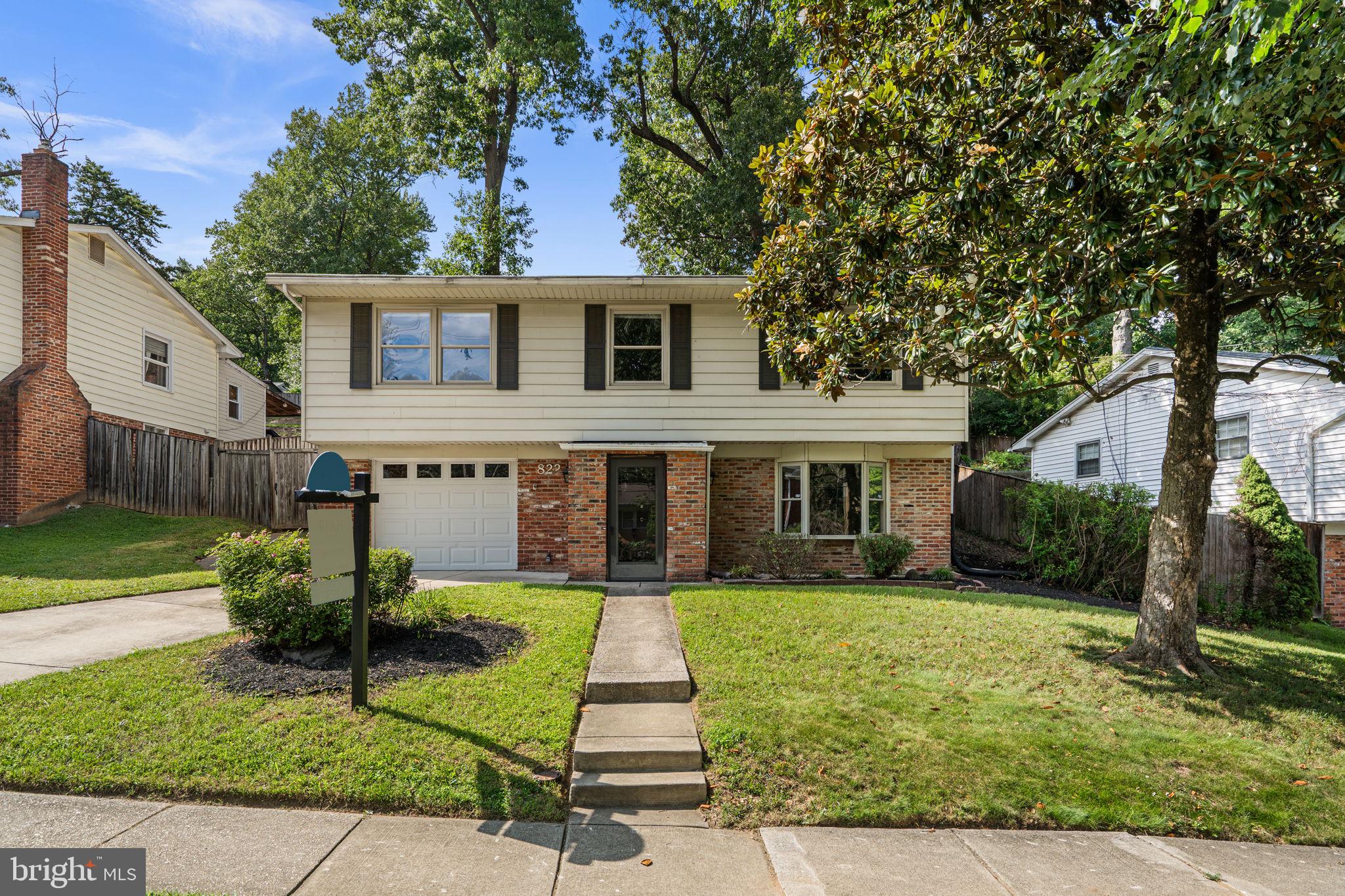 Welcome to 822 Loxford Terrace, a beautifully maintained and thoughtfully updated home in Silver Spring's Forest Knolls neighborhood. Offering three bedrooms, two full bathrooms, one half bathroom, and a versatile den, this spacious residence combines comfortable everyday living with flexible spaces that adapt to your needs.

From the moment you arrive, you'll notice one of the home's most distinctive features: an attached garage with an adjoining workshop and storage room. Rarely found in the surrounding area, this additional space provides endless possibilities for hobbies, projects, storage, or a dedicated work area. The home is further enhanced by a whole-house backup generator, a newer architectural composition shingle roof, and a new HVAC system installed in 2025.

Step inside the welcoming foyer and discover the lower-level family room, a warm and inviting space centered around a wood-burning fireplace. This level also features a private den that can easily serve as a home office, guest space, fitness room, creative studio, or playroom, along with a powder room, laundry area, and direct access to the garage.

Upstairs, hardwood floors and abundant natural light create a bright and cheerful atmosphere throughout the main living spaces. The spacious living room opens to the dining room and sunroom, where three skylights and expansive windows fill the space with natural light while overlooking the backyard and mature landscaping. Whether enjoying a quiet morning coffee or gathering with family and friends, this sun-filled room offers a wonderful connection to the outdoors throughout the year.

The updated kitchen provides generous workspace and storage with extensive cabinetry, stainless steel appliances, ample counter space, and a new refrigerator installed in December 2025.
Down the hallway, you'll find three comfortable bedrooms, including a primary suite designed as a peaceful retreat. The renovated primary bathroom features heated tile floors, granite countertops, a clawfoot soaking tub, a walk-in shower with three shower heads, a private water closet, and beautiful natural light. Two additional bedrooms offer excellent closet space and share an updated hall bathroom.

Outside, the property's natural topography, mature trees, and established landscaping create privacy, seasonal beauty, and visual interest. The elevated setting enhances the home's presence while providing attractive views and a sense of separation from neighboring properties.

Forest Knolls is known for its strong community spirit and exceptional access to outdoor recreation. Residents enjoy nearby access to the Northwest Branch Trail system for hiking, biking, and nature walks, as well as the neighborhood's membership pool. Forest Knolls Elementary School and Northwood High School are both within walking distance, allowing students to travel to school without crossing major roadways—a convenience that families particularly appreciate.

Combining generous living space, thoughtful updates, significant system improvements, and unique amenities such as the attached garage, workshop, and whole-house generator, 822 Loxford Terrace offers an exceptional opportunity to enjoy a well-cared-for home in one of Silver Spring's most established neighborhoods