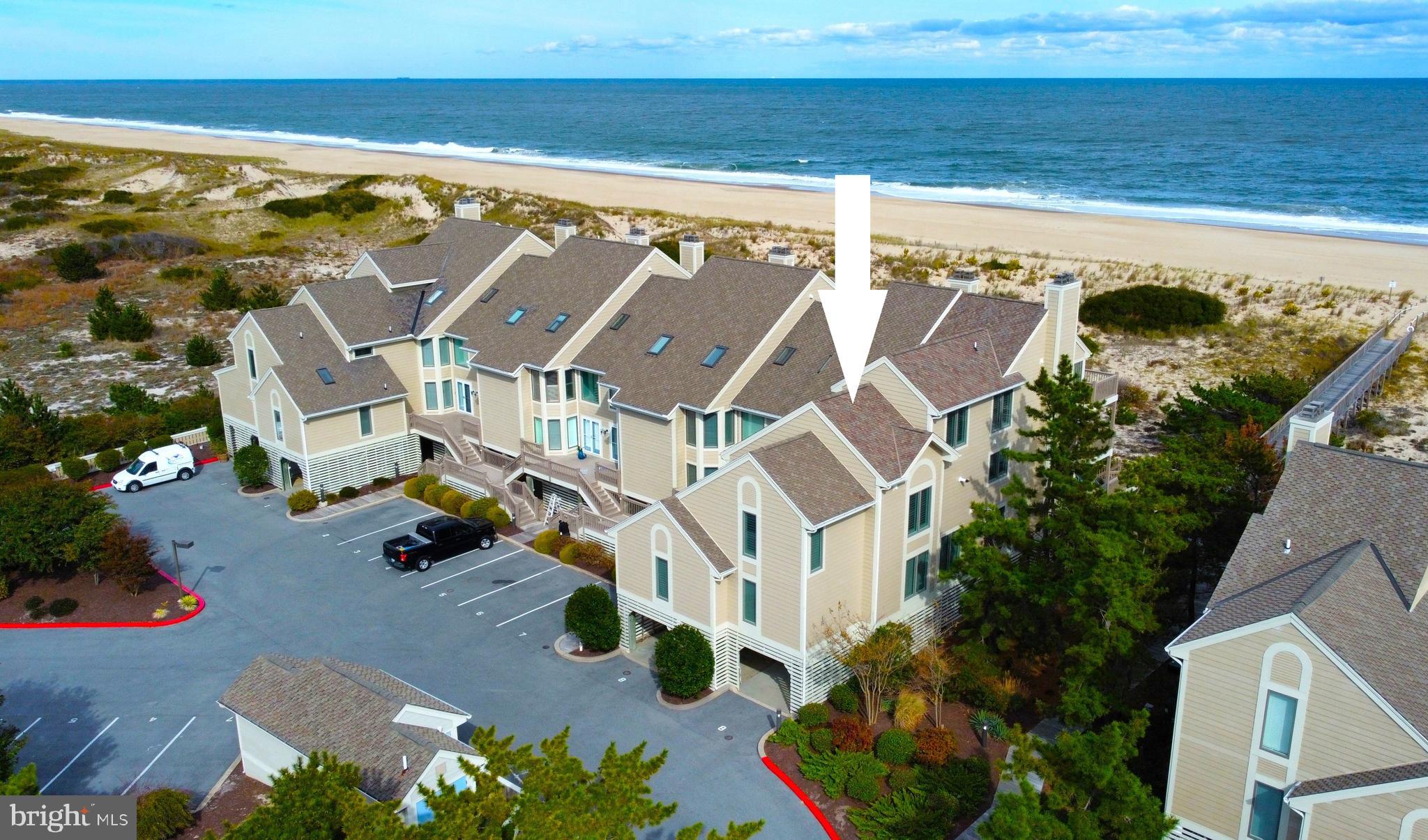 Exquisite Oceanfront home that has been expanded to nearly double the original square footage which makes this end townhome live like a single family home. This impressive property was beautifully renovated with high end finishes and features throughout and is offered with designer furnishings.  Step inside to the main living level which features an inviting floorplan with the kitchen open to the dining and living areas that spill onto the oceanfront deck, creating an ideal layout for multiple generations to gather at the beach.  In addition to the sliding glass doors along the oceanfront, the windows along the south wall allow for an abundance of natural light to spill into the heart of the home.  Also on this level is a den with an en-suite bathroom that could easily be a 6th bedroom along with a powder room and a home gym.  Step upstairs to the grand oceanfront primary suite with expansive views of the beach both inside and out. This room offers a private deck overlooking the ocean, walk-in closet, and a spa-like bathroom with glass and tiled shower, jetted soaking tub, and double vanity.  Also on this floor are two additional bedrooms with private bathrooms, laundry and a small loft area currently used as a gaming nook. The third level features a second oceanfront suite with dramatic views of the coastline, a private oceanfront balcony and en-suite bathroom. Also on this floor is a custom bunk room that will comfortably sleep 5 and another full bathroom plus additional laundry. Step directly from your oceanside deck onto the beach walkway to enjoy the sunrise over the ocean and catch captivating sunsets on the bay from your entry level deck. The covered ground level offers 2 outside showers, storage room for all of your beach necessities, and covered parking for 4 vehicles. This is a rare opportunity to have this amount of living space in Kings Grant, a community that borders both the Ocean and Bay, offering a community swimming pool and pier for fishing, crabbing, and kayak launching.