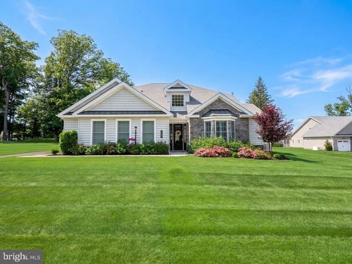 One of only eleven ONE-ACRE homesites in Traditions of Locust Valley, this exceptional 2024-built residence offers a unique blend of LUXURY, PRIVACY, and SCALE seldom found within Lehigh Valley 55+ living. Spanning 3,673 square feet, the home showcases SOARING ceilings, extensive wainscoting, and thoughtfully selected finishes. Enjoy the ease of first-floor living without compromise on space or sophistication. The impressive Primary Suite serves as a PRIVATE RETREAT, complete with two walk-in closets, while a welcoming Guest Bedroom and full bath provide comfort and convenience for visitors. Thoughtfully designed for both everyday living and entertaining, the main level also features a SPACIOUS PRIVATE OFFICE, Elegant Dining Room, and a light-filled Sunroom overlooking the property. The well-appointed Kitchen showcases beautiful quartz countertops, premium stainless steel appliances and plenty of custom CABINETRY. A BUTLER'S PANTRY as well as a walk-in pantry with extensive shelving ensures that you have room for all of the essentials. Anchored by a dramatic floor-to-ceiling STONE FIREPLACE and enhanced by a custom beverage bar, the Great Room presents a warm yet sophisticated setting for gatherings large and small. The second level offers exceptional flexibility with an EXPANSIVE LOFT, private third bedroom, walk-in closet, and full bath—creating an ideal retreat for guests or extended family. From refined UPGRADES to modern technology, every detail has been considered. Highlights include a WHOLE-HOUSE GENERATOR, EV CHARGING STATION, enhanced internet connectivity throughout the home, and premium sod for exceptional outdoor presentation. Residents enjoy an AMENITY-RICH lifestyle with access to a Clubhouse, Fitness Center, Swimming Pool, and Pickleball Court. Combining newer construction, exceptional privacy, thoughtful upgrades, and elegant entertaining spaces, this premier property represents a distinguished offering within this sought after community.
