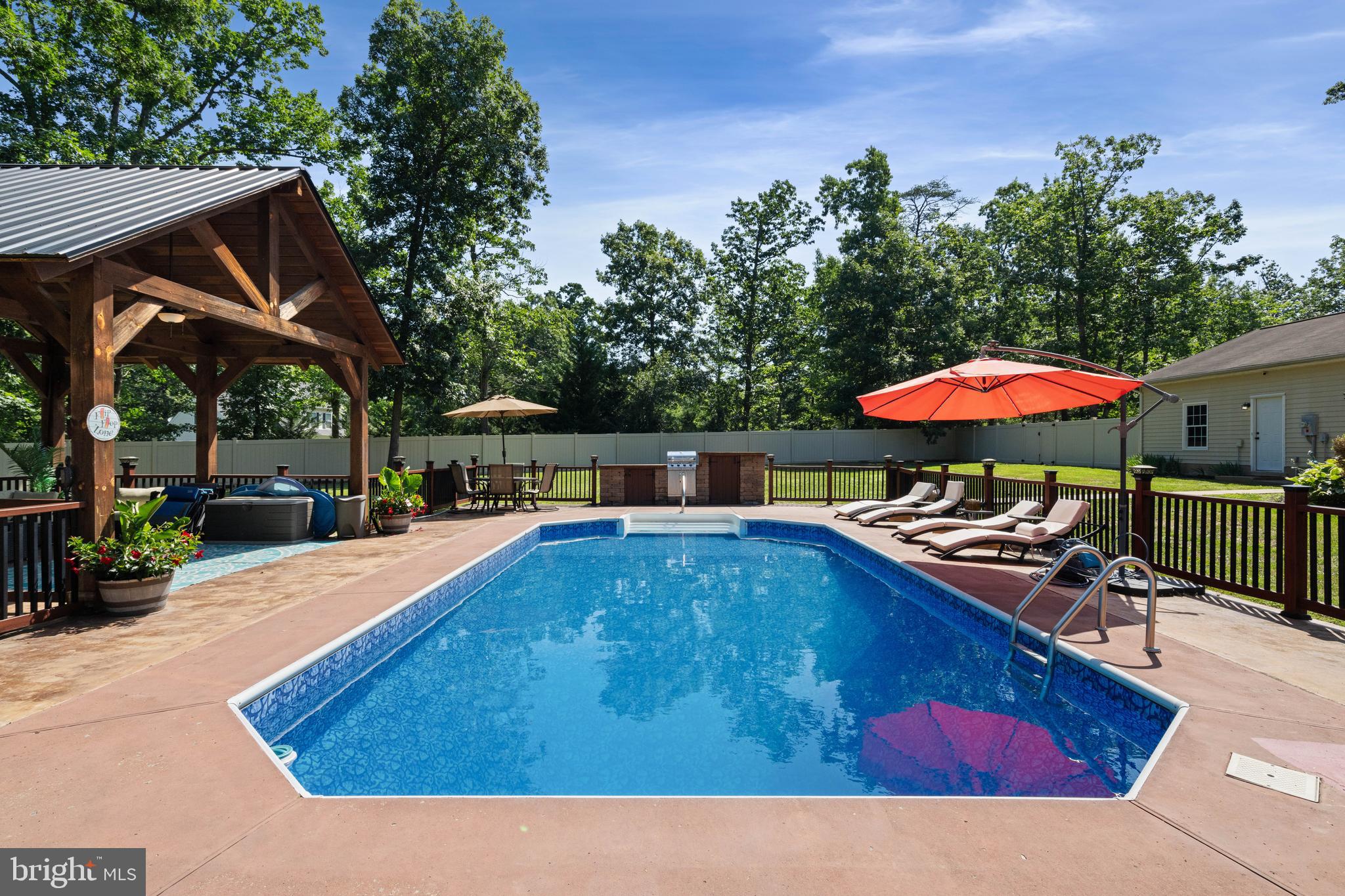 Prepare to be amazed by this exceptional 5-bedroom, 2-bath ranch home nestled on over 2 beautiful acres. Offering the perfect blend of comfort, character, and outdoor living, this property is much more than a home—it's a private retreat designed for making memories.

From the moment you arrive, you'll appreciate the paved driveway, expansive parking areas, attached garage with office space, and oversized outbuilding perfect for storing your boat, camper, ATVs, lawn equipment, workshop tools, or all your favorite toys.

Inside, beautiful hardwood floors add warmth and character throughout much of the home. The inviting family room features a stunning floor-to-ceiling stone fireplace with custom built-ins, creating the perfect gathering space. The kitchen is both functional and charming, featuring granite countertops, stainless steel appliances, abundant cabinetry, a cast iron double sink, custom barnwood-inspired trim, and thoughtful details throughout.

One of the home's most unique features is the lodge-inspired primary bedroom, complete with soaring vaulted wood ceilings, custom built-ins, a stone-faced gas fireplace, and a walk-in closet that creates a cozy retreat unlike anything else on the market.

This home is special both inside and out.

Step into your own private backyard paradise surrounded by an impressive vinyl privacy fence. The inground pool, expansive patio areas, incredible outdoor kitchen, dedicated fire pit area, and stunning timber-frame pavilion with metal roof and ceiling fans create an unforgettable setting for entertaining family and friends. Whether you're hosting summer pool parties, enjoying game day gatherings, grilling by the pool, gathering around the fire pit on cool evenings, or simply relaxing under the pavilion, this outdoor space was designed to be enjoyed.

Properties that offer this level of outdoor living, privacy, and versatility are hard to find. With over 2 acres, 5 bedrooms, multiple outbuildings, and a resort-style backyard, this retreat delivers a lifestyle you'll enjoy year-round.

* New August 2025: A/C, Furnace, Pool Liner, Cover and Motor!