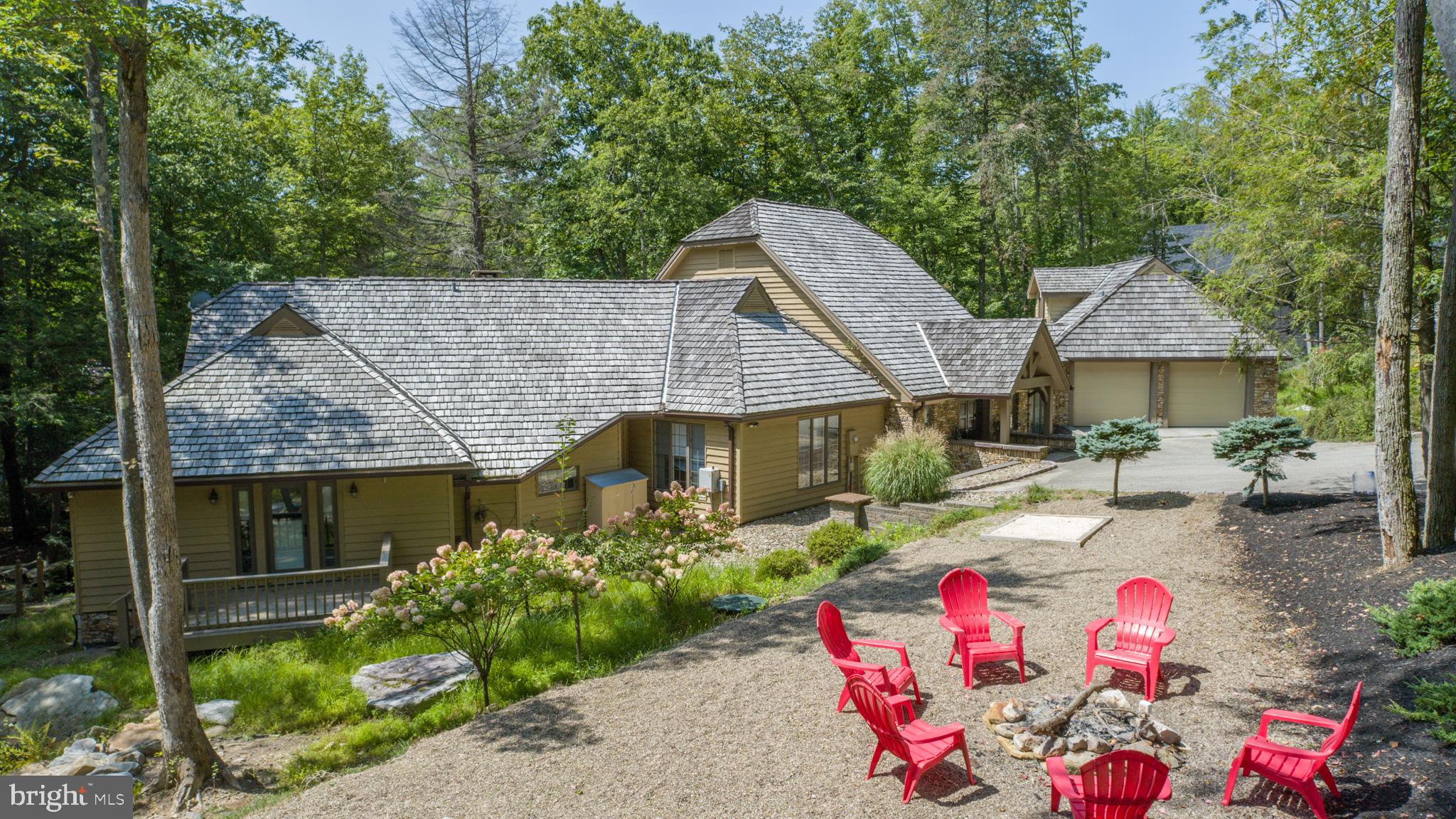 Charming Lakefront Craftsman on Stockslager Rd – This 5 Bedroom, 4.5 Bathroom lakefront estate is situated on 1.25 acres of wooded land and features a detached carriage house with a game room, sprawling back deck overlooking Deep Creek Lake, and 270’ of level lakefront. Boardwalk patio down to your Type A dock and lakeside bar. Attached 2-car garage with EV charger and an in-law suite upstairs. Tastefully updated modern kitchen with granite counters and stainless appliances. Rustic timber logs and stone fireplace in the great room. Plenty of glass throughout the main level to let in the natural light. Lots of seating/dining areas for entertaining, including a fully enclosed sunroom. Nestled into a private cove, yet minutes from local restaurants, state parks, and Wisp Resort. This eclectic modern contemporary has endless potential. Call today for your private showing!