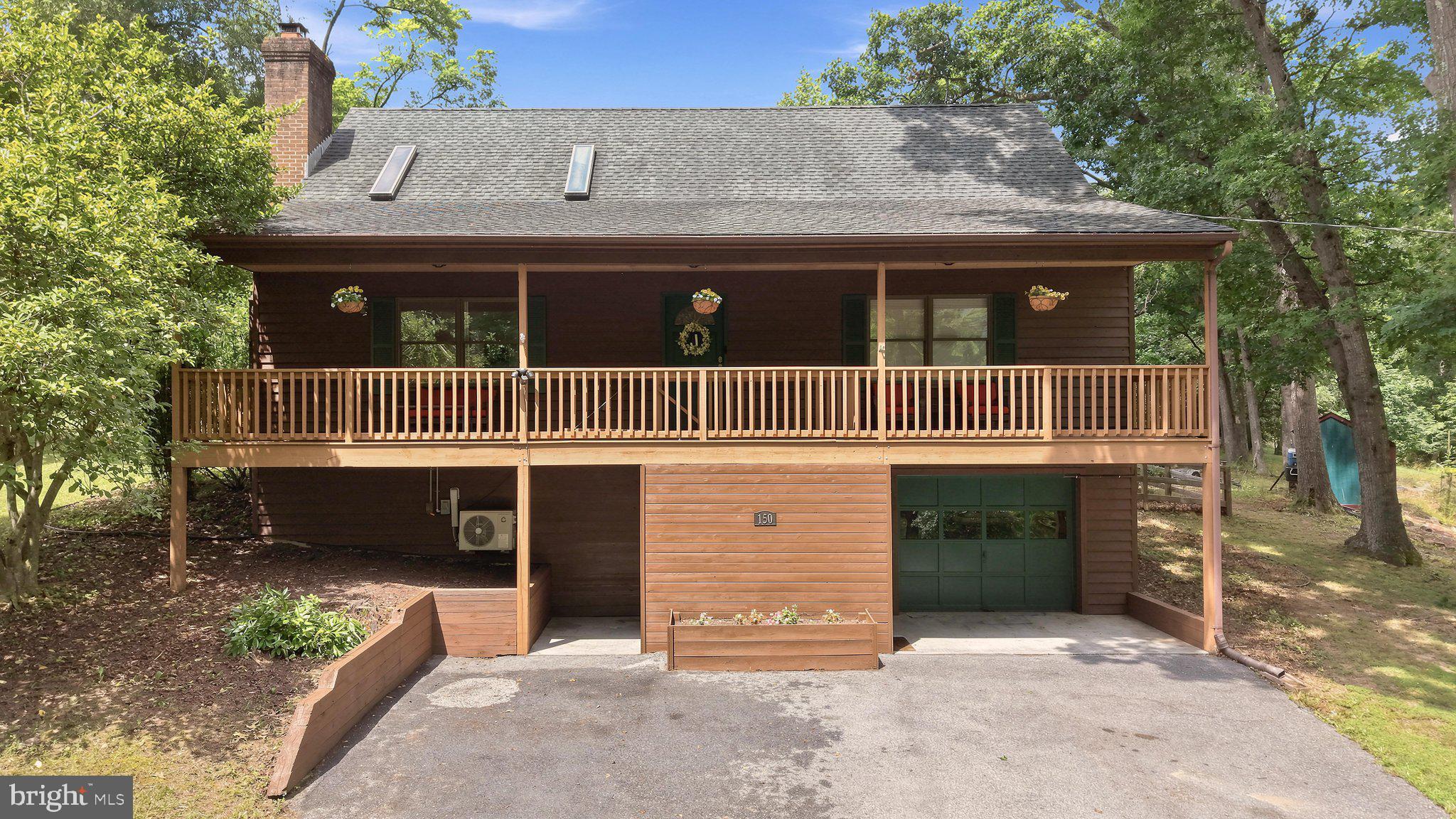 BEAUTIFULLY UPDATED 5-BEDROOM HOME nestled among mature trees in the gated community of Lake Holiday! The fully fenced backyard is one of this home's standout features, backing to protected community common area for exceptional privacy with direct access to scenic walking trails leading to the lake, ponds, playgrounds, and community bus stop. Enjoy peaceful mornings or entertain guests on the spacious 16' x 12' awning-covered deck surrounded by nature. Inside, soaring vaulted ceilings with skylights, hardwood flooring, and a striking whitewashed brick fireplace with a thermostat-controlled pellet stove create a warm, inviting atmosphere. The updated kitchen showcases stainless steel appliances, painted cabinetry, luxury vinyl plank flooring, decorative stone accents, tile backsplash, and pantry shelving. The thoughtfully designed floor plan offers two spacious bedrooms and an updated full bath with jetted tub on the main level. Upstairs, the private primary suite features vaulted ceilings, a skylight, dual closets, and a beautifully remodeled spa-inspired bath with a jetted tub and separate shower. Two additional upper-level bedrooms provide plenty of space for family, guests, or a home office. The walkout lower level expands your living space with a large family room, exercise or flex room, abundant storage, and a rough-in for a future full bath. Recent updates include a newer oven and microwave, brand-new front-load washer and dryer, refinished deck, newer rear fencing, freshly painted interior, and new closet and sliding doors. An oversized one-car garage with built-in shelving and a workbench provides excellent storage and workspace. Move-in ready and ideally located just minutes from the front gate for an easy commute while enjoying all the amenities Lake Holiday has to offer, including a 240-acre lake, beaches, fishing, boating, tennis and basketball courts, dog park, clubhouse, and year-round community events.
