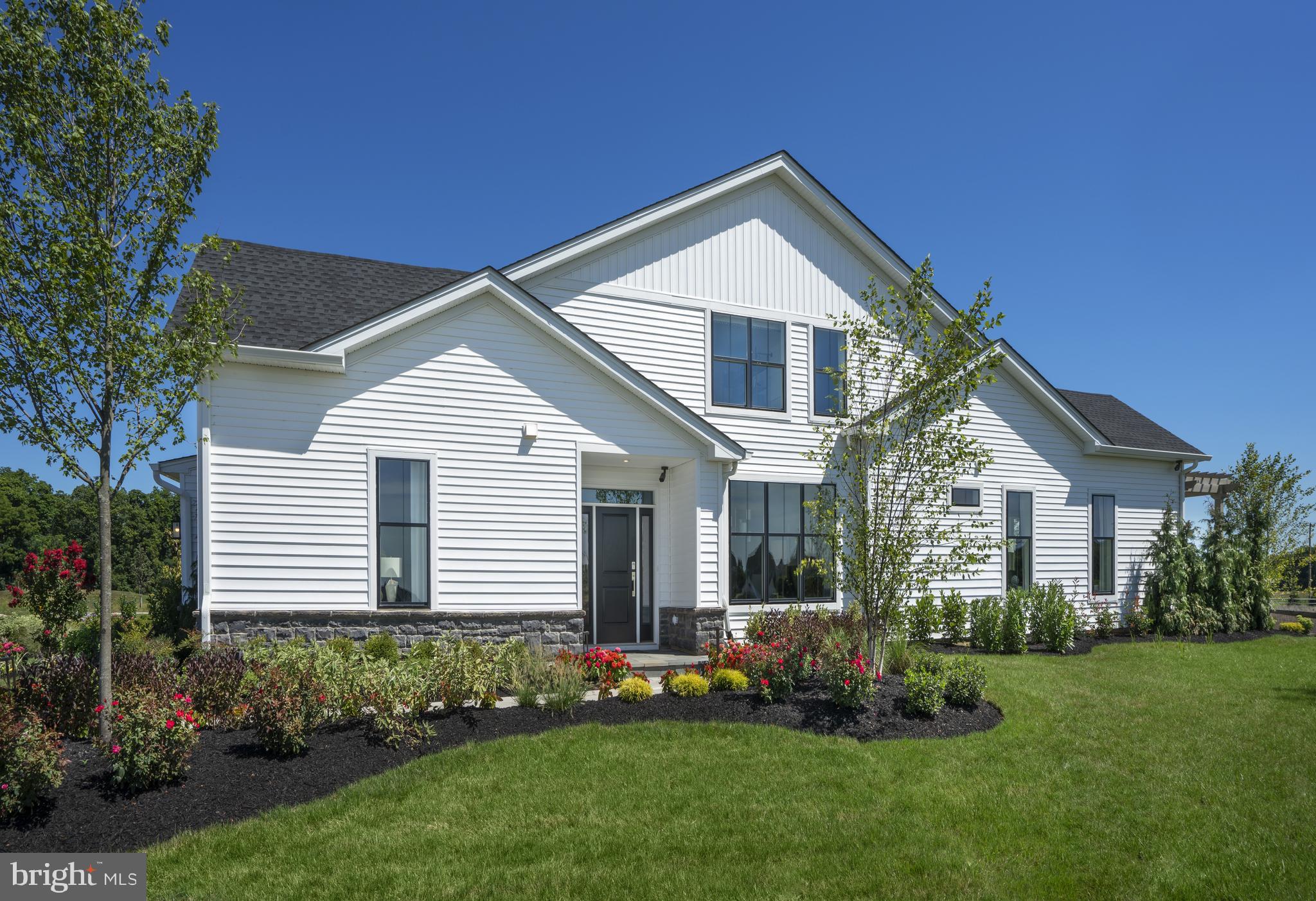 55+ Luxury Community. FIRST FLOOR PRIMARY BEDROOM SUITE! Quick-Move-In Homesite lot 217 will be ready for you late Spring of 2022! This COVERDALE MODERN FARMHOUSE floorplan offers an expanded, first floor primary bedroom suite featuring tray ceiling & fully tiled  OVERSIZED bath retreat. At 2073SF this home also showcases 9 ft. ceilings throughout the first floor plus a raised 11' high ceiling in the expanded Great Room. Enjoy upgraded interior finishes including  wide plank hardwood in the main living space. The kitchen is light and airy with tall windows and features SS appliances, 42" white cabinetry with contrasting island cabinetry in pewter, quartz countertops, & beveled back splash. Plus, there is a Loft for even more space and storage! Walk to your new, private, community clubhouse with 5,700 square feet of indoor recreation space plus outdoor swimming pool, bocce ball courts, pickleball courts, putting green, and more! Low-maintenance lifestyle that includes lawn care, landscaping, trash & snow removal. *Decorated model photos for representation.