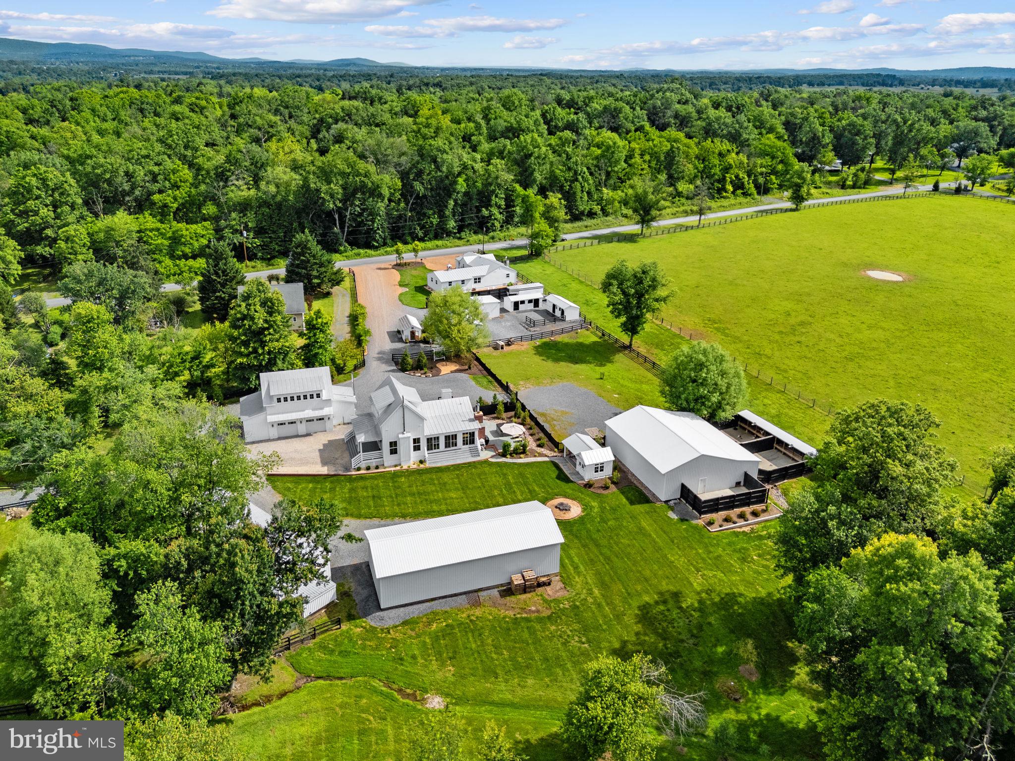 **35317, 35321, 35327 Snake Hill Rd Middleburg VA 20117**

Whitehall is an extraordinary private Hunt Country compound just minutes from the Town of Middleburg. Thoughtfully created over more than a decade by an experienced builder, the property includes three independent residences, nearly 12,000± square feet of architecturally cohesive improvements, mature landscaping, and exceptional infrastructure designed for effortless country living.

The compound offers approximately 7,000± square feet of finished living space across three independent residences plus 5,000± square feet of garages, covered outdoor living areas, conditioned storage, workshop space, and accessory buildings. The main residence was custom built in 2016. Improvements include a beautifully designed carriage house with apartment, office, fitness space, and wine cellar, and a fully renovated guest residence that has successfully operated as a private short-term rental.

Surrounded by permanently protected countryside with Blue Ridge Mountain views, the property features specimen trees, flowering gardens, orchards, a greenhouse, expansive lawns, flagstone walkways, and multiple outdoor entertaining areas. Public sewer, 600-amp electrical service, lifetime standing-seam metal roofs, modern infrastructure, and conscientious stewardship provide true turnkey ownership with no deferred maintenance.

Ideally positioned at the gateway to Middleburg’s renowned gravel road network and just minutes from Salamander Resort, Goodstone Inn, wineries, restaurants, and shopping, Whitehall is perfectly suited as a private family estate, multigenerational compound, executive retreat, or luxury hospitality property. Opportunities to acquire a property offering three independent residences, exceptional flexibility, timeless architecture, and one of the finest locations in Virginia Hunt Country are exceedingly rare.