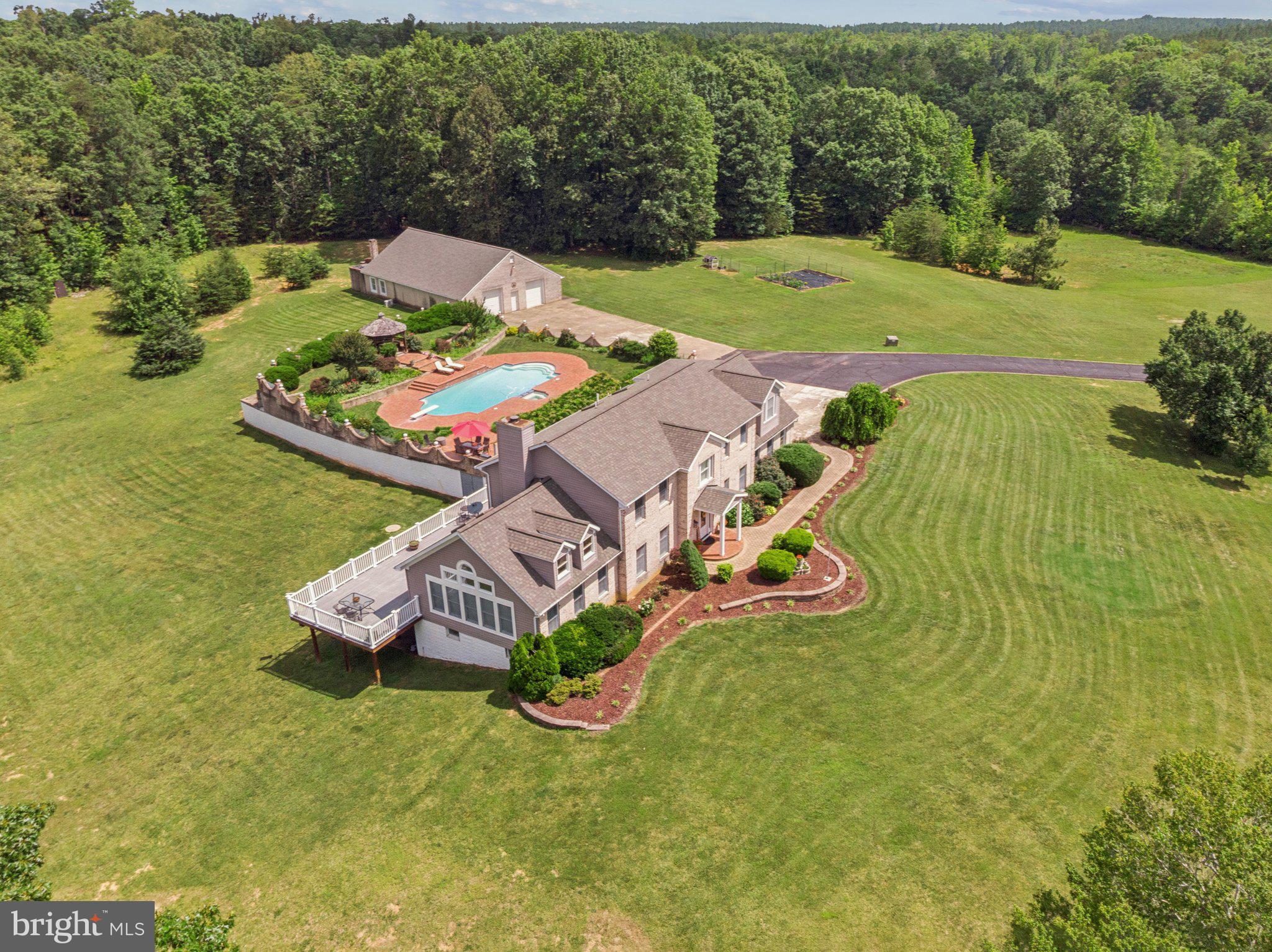 **Private Estate on 50 Acres with Pond, Guest Apartment & Out Building/Workshop **

Welcome to your private retreat! Tucked behind an electric gate and accessed by a scenic paved driveway, this impressive 50-acre property offers privacy, luxury, and versatility like no other.  Close proximity to Fredericksburg, Stafford and Warrenton!

The **main residence** features:

* 5 spacious bedrooms and 4.5 bathrooms
* A full finished basement, ideal for entertaining or multi-generational living
* Attached 2-car garage
* Tyvek decking with stunning views of the surrounding landscape
* A beautiful **in-ground pool with lanai and gazebo**, perfect for outdoor living and summer gatherings

The **detached guest apartment** offers even more space and functionality:

* 2 bedrooms, a full kitchen, and a full bath
* Attached 2-car garage with additional room for lawn equipment, storage, or a workshop
* **A smokehouse attached to the garage apartment**, perfect for hobbyists or those who enjoy home smoking and curing

Across the picturesque **3-acre pond**, stocked with crappie , bluegill and bass, you'll find a massive **outbuilding** with:

* Oversized garage bay large enough to accommodate a tractor trailer
* Finished office space and abundant storage
* A framed and roughed-in upper level for future living quarters — layout includes kitchen, living area, bedrooms, and bathrooms (drywall not yet installed)

**Outdoor enthusiasts will love the hunting potential** — the wooded acreage with trails offers prime habitat for deer, turkey, and other wildlife, making it ideal for recreational use or managing your own private hunting grounds. Perfect for horse enthusiasts as well, plenty of space to build riding arena and stalls.

Significant updates include **new siding and roofs installed in 2021** on the main house, guest apartment, and outbuilding.

**Property is being sold as-is.** Overall, it’s in great shape with well-maintained systems and structures.

Whether you're looking for a family compound, a private getaway, or space for a home-based business or hobby, this exceptional property delivers it all. Schedule your private showing today and explore the possibilities this rare offering provides