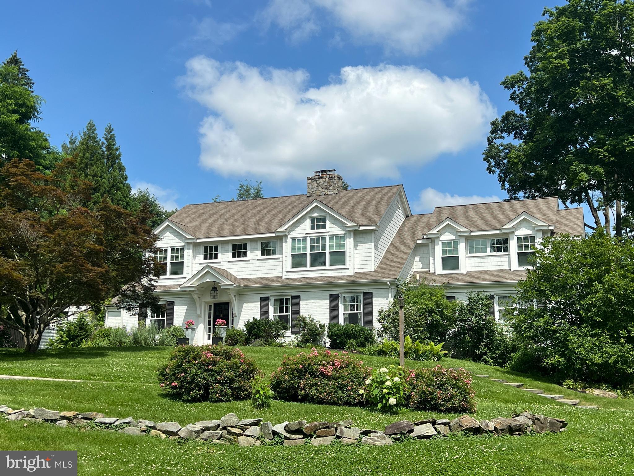 Quintessential and oozing with style, this New England Colonial is set on a hill and has a quiet and completely private 1 acre lot with a stunning pool and multiple enchanting outdoor entertaining spaces. This flexible floor plan allows for 5-7 bedrooms or 5 bedrooms and his &  hers offices.  The private first floor wing  could also be used as an in-law or au-pair suite. There are 3 full baths and one main level powder room. Retreat to your gorgeous primary suite upstairs with a dramatic vaulted ceiling, custom beams and spa like primary bath with a top of the line Kohler vibrcoustic soaking tub. There is a finished lower level including  family room with bar, exercise room and a to die for huge 4 car garage. It is evident that this designer's own residence has been impeccably curated with attention to every space inside and out. Sure to impress.