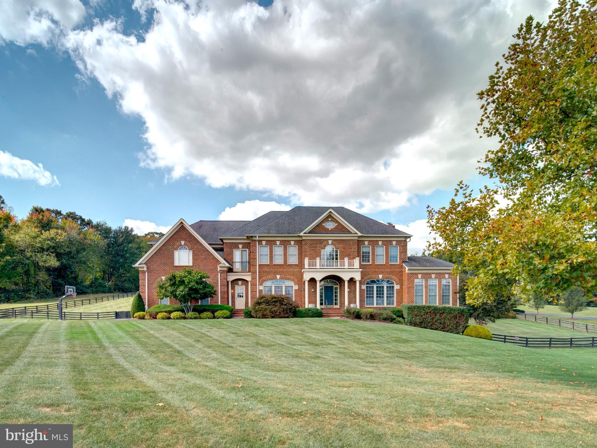 Welcome to your dream oasis, uniquely nestled in one of the Loudoun’s prime communities. This breathtaking property spans an impressive 3 acres offering serene panoramic views of rolling hills that paint a stunning backdrop to everyday life. Designed with elegance and dramatic flair this Renaissance Grand Michaelangelo reflects luxury and sophistication. As you approach the all-brick facade, you are immediately greeted by stylish accents and unique trim that set the tone for what lies within. Step inside to discover a soaring main floor with gorgeous wood floors that flow throughout, leading you into the heart of the home. The magnificent spiral staircase commands attention and serves as a stunning architectural centerpiece, inviting all who enter to experience the grandeur this home offers.
Culinary enthusiasts will fall in love with the gourmet kitchen, outfitted with designer appliances that make entertaining a breeze. The spacious layout ensures that guests can gather, as meals are prepared in style. Whether hosting a dinner party or enjoying a quiet family meal, the large windows show off the panoramic rear landscape and resort like amenities. The grand master suite with 4 closets, private office and large spa like lux bath is a true retreat, boasting ample space and luxury amenities that offer a serene escape at the end of the day.  With a total of 5 bedrooms, each with a private en-suite bath, there is no shortage of space for family and guests to feel at home. Venture down to the fully finished walkout lower level where you will find a designer basement that redefines relaxation and entertainment. This versatile space is perfect for movie nights, family gatherings, or hosting friends for the big game.
Step outside into your private resort-like backyard, where tranquility and luxury collide. The infinity edge pool beckons on warm sunny days, while the adjacent pool house, complete with a cozy fireplace and bar, sets the stage for unforgettable summer nights spent under the stars. This home is more than just a property... it’s a lifestyle. With its unique details, sophisticated design, 4 car garage and prime location, it offers not just a place to live, but a sanctuary to thrive. Don’t miss your chance to own this extraordinary masterpiece. Located 10 Minutes from Downtown Leesburg and Brambleton Town Center and just 15 Minutes from Dulles Airport.  Schedule your private tour today and let your dreams take flight in this exquisite residence.