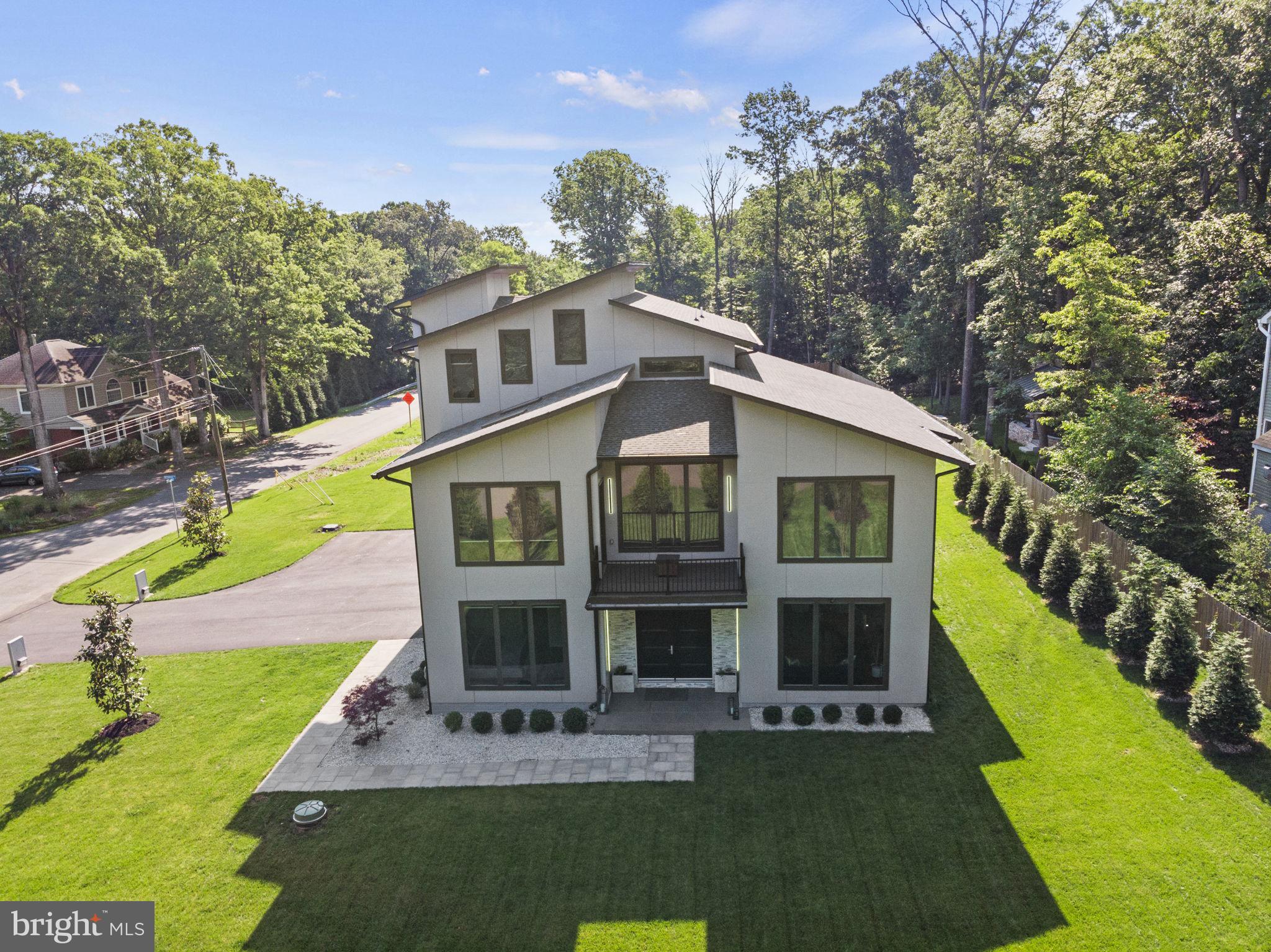 Nestled on a premium one-acre corner lot, this stunning 5 bedroom, 6 and a half bathroom, 1.5 year newly built home features an open concept design and exceptional craftsmanship with 10 foot + ceilings throughout 5400 square feet on 3 levels.  An entry level guest suite and a three-car attached garage add to the functionality and comfort of the home.  Features include  8 foot tall interior doors with a solid wood custom main door and architectural light fixtures.   The gourmet kitchen is a chef's delight, equipped with all professional grade Monogram appliances including a 48” range with hood, counter depth refrigerator, ss dishwasher and built in microwave. Venture through the family room's oversized glass sliding doors to the spacious screened in patio, perfect for unwinding and entertaining amidst a beautifully landscaped back yard complete with with green giant evergreens. The second level master features a spa-like en-suite with heated floors, double vanities, a luxurious glass-enclosed shower and standalone soaking tub.  Enjoy a convenient coffee bar, treetop views from a spacious sitting area, and an oversized walk-in closet with built-ins.   On the upper level, you'll find an entertainment space complete with a wet bar, an additional full bathroom, a balcony, and elegant vaulted ceilings.  Suitable for an adjacent secondary home, this lot offers endless possibilities for your vision.  Conveniently situated near Route 7, parks, golf clubs, Dulles airport and downtown One Loudoun’s vibrant array of shops and restaurants, this home epitomizes luxury living and accessibility.   Call and schedule your tour today!