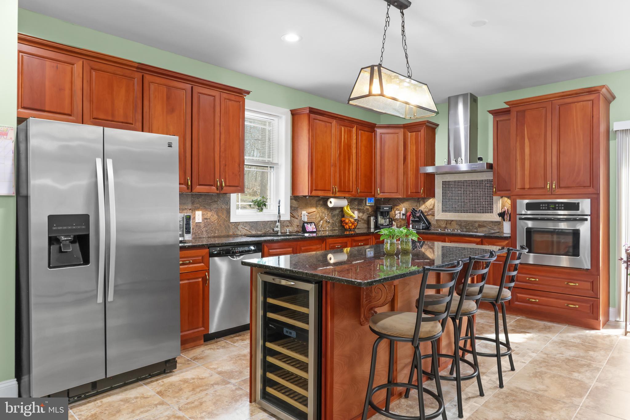 Over 5,400 SQ FT of Luxury Living with an IN-LAW SUITE for Extended Family and Guests within Saw Creek Estates of the Poconos. This expansive home, newly built in 2009, will be the go-to for hosting, with room for all. Entertain in the large open dining room for family gatherings, a high-end kitchen with island seating and a wine fridge to gather around, and the spacious living room. Double door entry, hardwood flooring, 10 ft ceilings are just a touch of the high-end finishes, and a large laundry room and walk-in pantry storage lends convenience. French doors to the large bonus den/office to work from home or host the playroom. Retreat to your Primary Bedroom and en suite with an extraordinary shower and bath, tray ceilings, and a walk-in closet with custom shelving. As one of 3 beds and 2-1/2 baths on just the main level. The finished walk-out Lower Level boasts a fully equipped additional 3 bedroom 1-1/2 bath in-law suite with full kitchen, open concept large living areas, and plenty of storage. Keep the home cozy and efficient in the winter with both a wood stove on the main level and a pellet stove in the lower level. Plus a new hot water heater, a new grinder pump. Located within the most amenity-filled community with pools, lakes, a fitness center, tennis courts, playgrounds, skiing, and more. With wooded, peaceful surroundings on a corner lot, this home delivers space, sophistication, and true multi-generational living.  Ask how to receive up to $5,000 lender credit towards closing costs or lowering your interest rate!