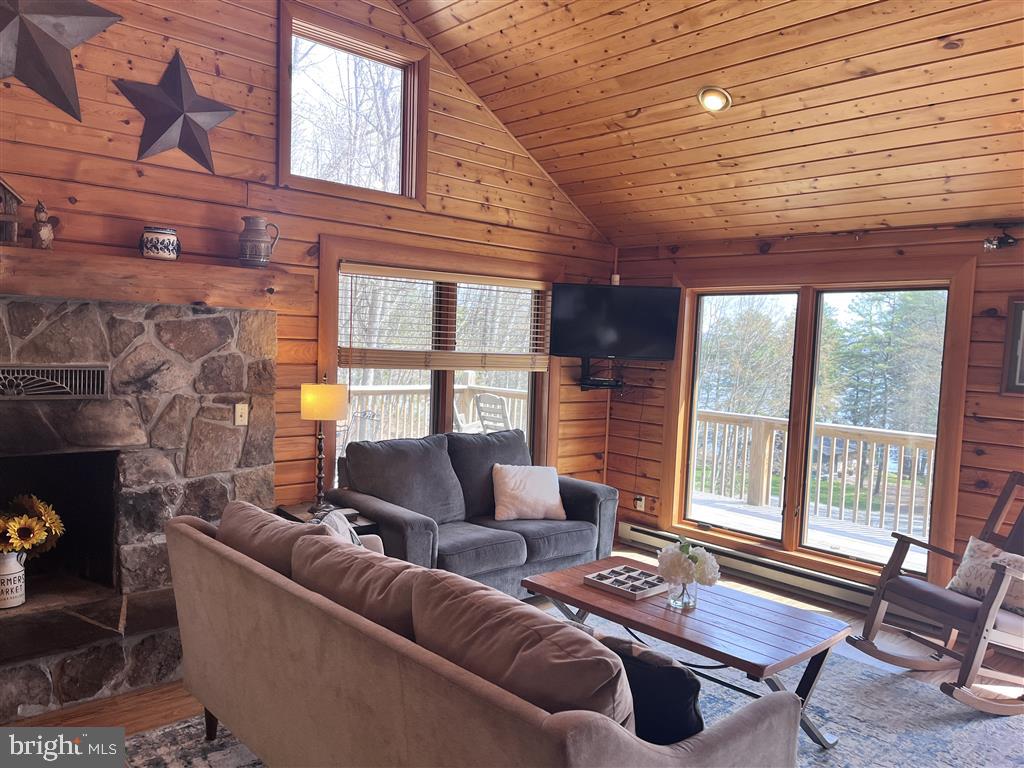 Beautifully renovated lake access log cabin with a deeded dock slip in a quiet cove with private 29 acres of trails (ATVs/snowmobiles permitted). Recent renovations (approx. $200K) include new wrap around deck, new roof, re-stained siding, new kitchen with granite counters, new appliances, new bathrooms, new LVFs throughout the house, new 2 car garage doors, new mini-split heat and A/C units, and mostly new Pella windows and furniture. Selling fully furnished. Enjoy stargazing on a quiet street in front of a fire pit or in your private hot tub. Filtered lake views with the deeded dock slip across the street. Centrally located in the mid-lake area, close to ski resort, beach, and state parks.