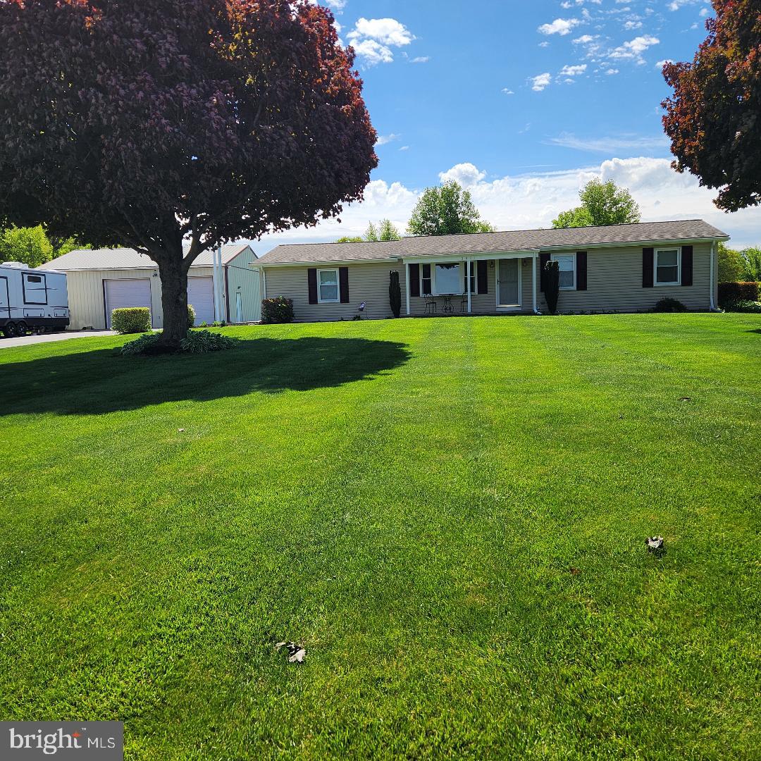 This beautifully kept rancher is nestled on a corner lot with nearly an acre.  From the front porch and rear you can see for miles, farmland, pond, and nature abound.  Enjoy the well-kept 4-bedroom 2 bath home, or the expansive heated and water supplied pole barn.  This added feature provides a full bar set up in a conditioned space, as well as ample parking to entertain as your heart desires.  This property also offers an underground pet fence