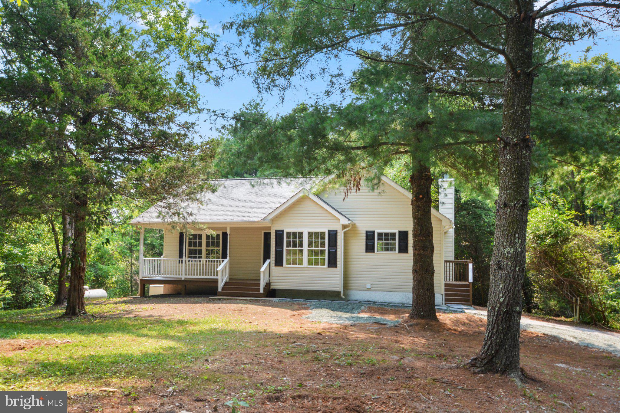 Escape to 10 picturesque acres in Scottsville with this beautifully updated 3-bedroom, 3-bathroom home, ready for you to move right in. Vaulted ceilings crown the open kitchen and living room, where hardwood floors and a cozy wood-burning fireplace (as-is) create instant warmth. The stunning updated kitchen boasts new stainless steel appliances, gleaming quartz countertops, and brand-new cabinetry, perfect for everyday living and entertaining alike. Two spacious main-level bedrooms with new carpet enjoy access to tastefully updated bathrooms, including a private primary suite with a generous walk-in closet. Downstairs, the partially finished lower level offers a finished living room with new carpet, a third bedroom with two walk-in closets, a full updated hallway bathroom, and fresh new carpet throughout, plus an unfinished laundry and utility area. Outside, unwind on the covered front porch, entertain on the covered back deck, or relax on the ground-level patio with direct walkout basement access, all set against a backdrop of total privacy. A backup generator and above-ground propane tank convey as-is. Move-in ready and waiting for you. Schedule your tour on ShowingTime today and see why this home stands out!
