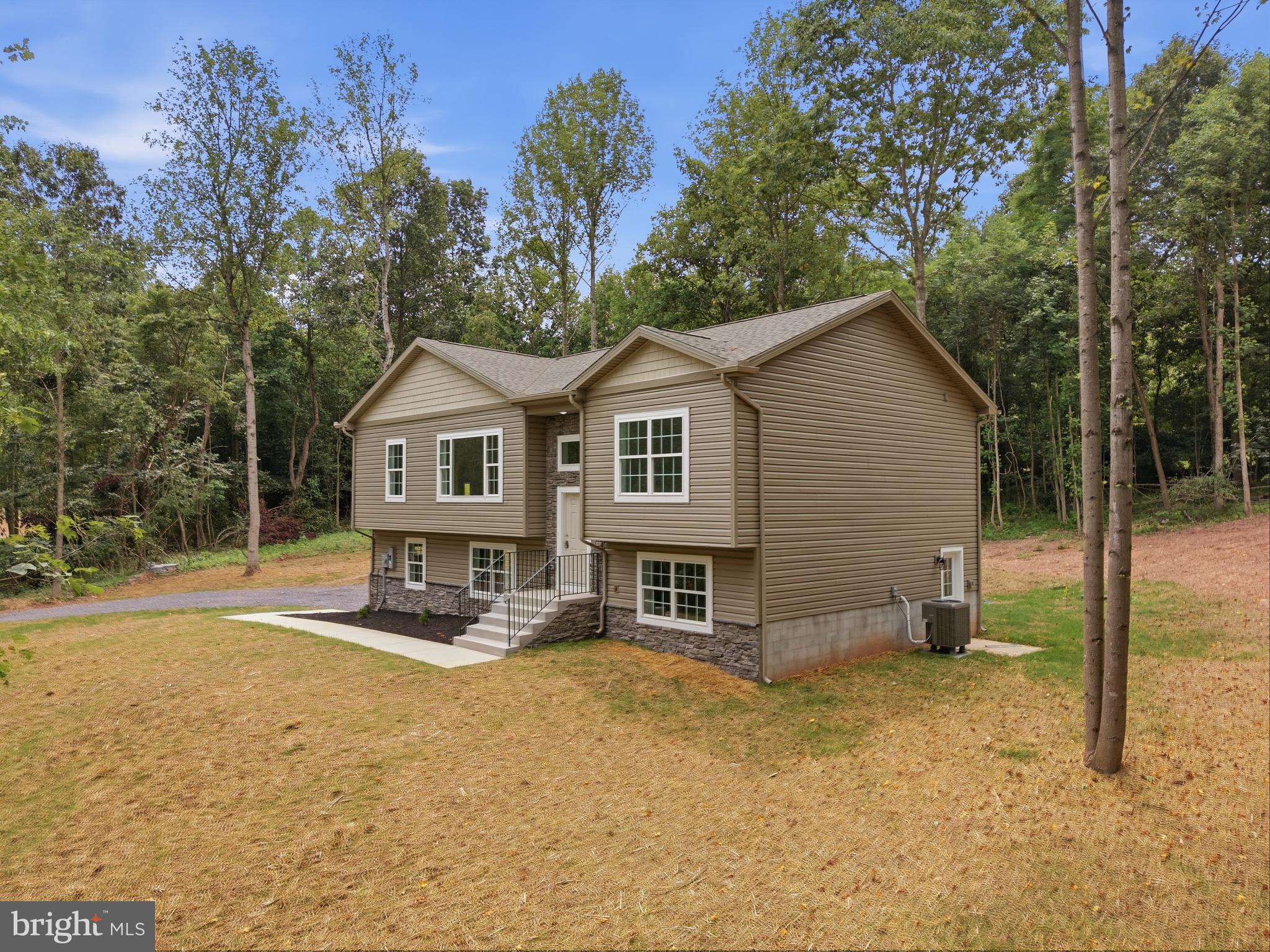 Welcome to 131 Triumph Ln,  where modern new construction meets the privacy, seclusion, and freedom of country living. Situated on 2.66 acres with no HOA, this beautifully built 2026 split foyer offers 3 bedrooms, 2 full baths, and 1 half bath, all thoughtfully designed with today's buyer in mind. The bright, open-concept main level creates an inviting space for both everyday living and entertaining. At the heart of the home is a stunning kitchen featuring granite countertops, stainless steel appliances, abundant cabinetry, an island, and a spacious pantry, making it as functional as it is beautiful. The spacious primary suite provides a relaxing retreat with a private ensuite complete with dual vanities, a corner soaking tub, and a tiled walk-in shower. Ceiling fans have been installed in every bedroom for added comfort, while luxury vinyl plank flooring extends throughout the main and lower living areas, with soft carpeting in the bedrooms. Downstairs, the finished lower level offers a generous recreation room that can easily serve as a family room, home office, gym, or playroom. You'll also find a deep two-car garage and an oversized driveway with ample parking for guests, trailers, or recreational vehicles. Located in a peaceful rural setting just minutes from I-81, you'll enjoy the tranquility of country living without sacrificing convenience. Finding a brand-new home on 2.66 acres with no HOA at this price is increasingly rare, making it an exceptional opportunity you won't want to miss.
