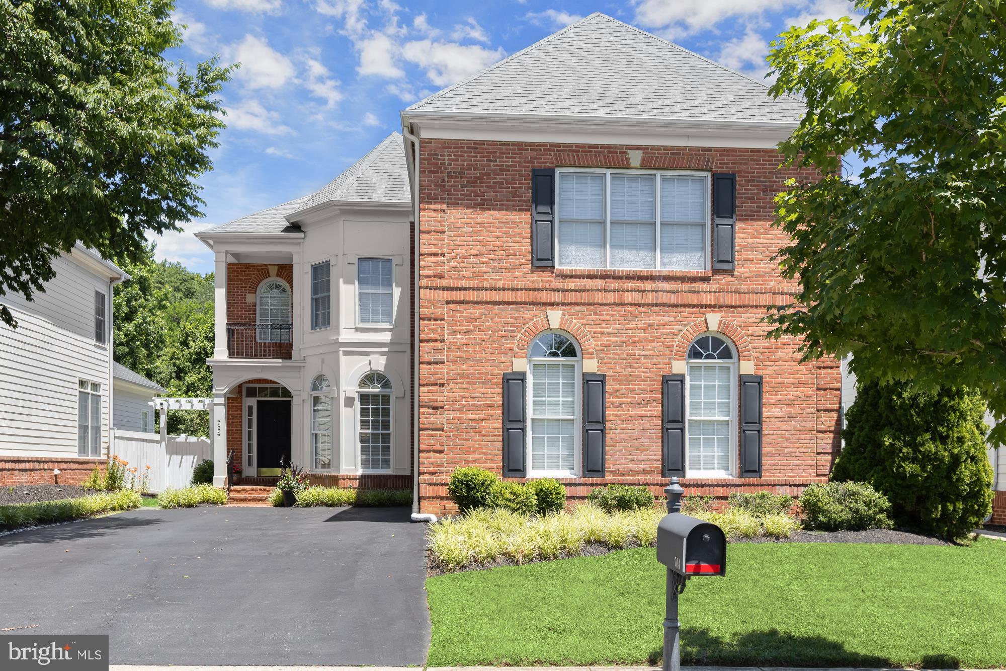 TIMELESS ARCHITECTURE & RESORT-STYLE LIVING IN KINGSPORT of ANNAPOLIS
Nestled within the highly sought-after community of Kingsport of Annapolis, this exceptional Neo-Traditional residence offers timeless architecture, thoughtfully curated designer updates, and an idyllic setting backing to mature trees. With five bedrooms, three full and one half baths, a finished walk-up lower level, and a side-entry two-car garage, the home blends elegant formal spaces with comfortable everyday living.
A classic brick front, Hardi-Plank siding, covered front porch, manicured landscaping, custom Hardi-Plank storage shed, fenced rear yard, pergola entry, raised stone garden bed, and expansive stone patio create outstanding curb appeal and inviting outdoor living spaces.
Inside, the entry foyer introduces beautifully proportioned living spaces filled with natural light and clad in hardwood floors. The formal living room is framed by architectural columns, multiple windows, and transoms, while the elegant dining room showcases a distinctive octagonal turret wrapped in plantation-shuttered windows. Privately tucked between the living room and great room, the study features French glass doors and tranquil views of the wooded rear landscape.
The wrap-around kitchen is designed for both entertaining and everyday living, featuring crisp white cabinetry, brushed gold hardware, contrasting quartz on the center island with breakfast bar seating, gas cooktop, and designer nautical pendant lighting. The spacious breakfast area, highlighted by a striking Sputnik chandelier, flows effortlessly into the spectacular two-story great room where soaring windows and stacked clerestory windows frame peaceful tree views and flood the home with natural light. A cozy gas fireplace anchors the space, while an atrium door opens directly to the stone patio, gardens, and fenced backyard, seamlessly blending indoor and outdoor living. An upgraded main-level laundry room adds everyday convenience.
Upstairs, an open loft provides the perfect work-from-home space overlooking the dramatic great room below. French doors welcome you into the luxurious primary suite featuring a tray ceiling, designer chandelier, sitting room, private balcony, and two spacious walk-in dressing closets. The renovated spa-inspired bath offers dual designer quartz vanities, custom feature walls, elegant sconces, a frameless glass shower, soaking tub, and plantation-shuttered windows. A generous ensuite bedroom with private bath and walk-in closet, plus two additional spacious bedrooms, complete the upper level.
The finished walk-up lower level offers exceptional flexibility with a spacious recreation room opening directly to the backyard, an oversized guest suite with luxury vinyl plank flooring, walk-in closet and adjacent full bath, a versatile flex room ideal as a home office, gym or overflow guest space, plus abundant storage.
Life in Kingsport is equally exceptional. Nestled along the scenic shores of Spa Creek and Back Creek, this award-winning planned community is known for its distinctive architecture, mature trees, village greens, pocket parks, sidewalks, tot lots, and beautifully landscaped common areas. Residents enjoy a resort-style pool and elegant brick pool house, signature stone monument entrance with fountain, walking and jogging trails, fishing dock, kayak launch, and water access. All this is located just minutes from Historic Downtown Annapolis, the U.S. Naval Academy, waterfront dining, shopping, marinas, and convenient commuter routes to Washington, D.C. and Baltimore.  Come home to a coastal inspired lifestyle with a vibrant neighborhood feel.