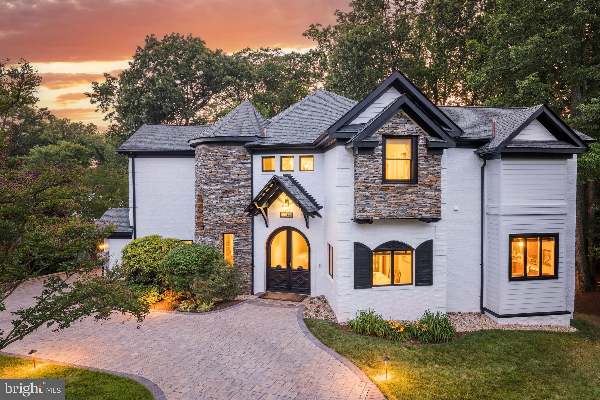 NEW PRICE! This captivating brick and stone residence is sited on a generous .4-acre lot in the heart of the Seven Corners area of Falls Church. Custom built in 2006 and spanning nearly 5500 square feet of living space, the home will surprise and delight with its timeless allure that incorporates contemporary design elements such as 12+ foot ceilings on all three levels, natural stone accents, barrel-rolled hallways, and cathedral and vaulted ceilings. The 6 bedrooms, 5 full and 2 half baths, home office and open study area, expansive wrap-round deck in the rear, screened in porch, and open floor plan are just a few features offering a symphony of impressive spaces for today’s modern living.   Upon entering through the double front doors, the grandeur of the home is immediately evident. The dining room, great room, gourmet kitchen and the home office all radiate off the rounded foyer, complimented by the circular staircase nestled in the turret to the left of the door. The kitchen stands as a culinary masterpiece, equipped with top-of-the-line appliances that include a JennAir double oven and Wolf cooktop on the large center island, along with beverage cooler, built-in microwave and Kitchen Aid refrigerator/freezer. Granite countertops, a walk-in pantry and window breakfast bar offer additional conveniences. Adjacent and open to kitchen is the great room with a wall of windows extending 2 stories up, electronic shades, a brick fireplace, and a French door to the elevated deck for seamless indoor-outdoor living and entertaining. The main level also features a home office clad in built-in shelving, a powder room, and a bedroom suite with a floor-to-ceiling bay window and adjoining full bath.   Upon ascending to the upper level, find a haven of relaxation and luxury. The spacious upper foyer stands open to the great room below, and incorporates an open study area with built-in desks. Three bedrooms, each with its own en-suite bath, walk-in closet, and unique ceiling designs, offer a private retreat for every member of the household. Ceiling fans in all rooms enhance comfort while adding a touch of elegance. The private and expansive owner’s suite offers two walk-in closets and a sumptuous bath featuring dual vanities, jetted tub and separate glass-enclosed shower, a private water closet, and an additional linen closet.   The lower level reveals a spacious recreation area that opens through double sliding doors to a screened porch and the expansive, private, fenced and tree-lined rear yard beyond. The uniquely high ceilings create an open and inviting atmosphere. A tiled area with full-sized refrigerator is ready for bar setup, while a brick fireplace adds an air of coziness, setting the stage for relaxation. This level also hosts a fitness or media room, two bedrooms or bonus rooms, and one full and one half bath. The newly carpeted floors on this level, complemented by tasteful tiling, create a balance of comfort and style.   The property’s other amenities include a paver circular drive, professionally landscaped yard, 2-car garage, new paint inside and out, updated light fixtures, and its close proximity to major roads to D.C., the Capital Beltway, shopping and dining. Don’t miss this move-in ready, elegant one-of-a-kind custom home that has it all!