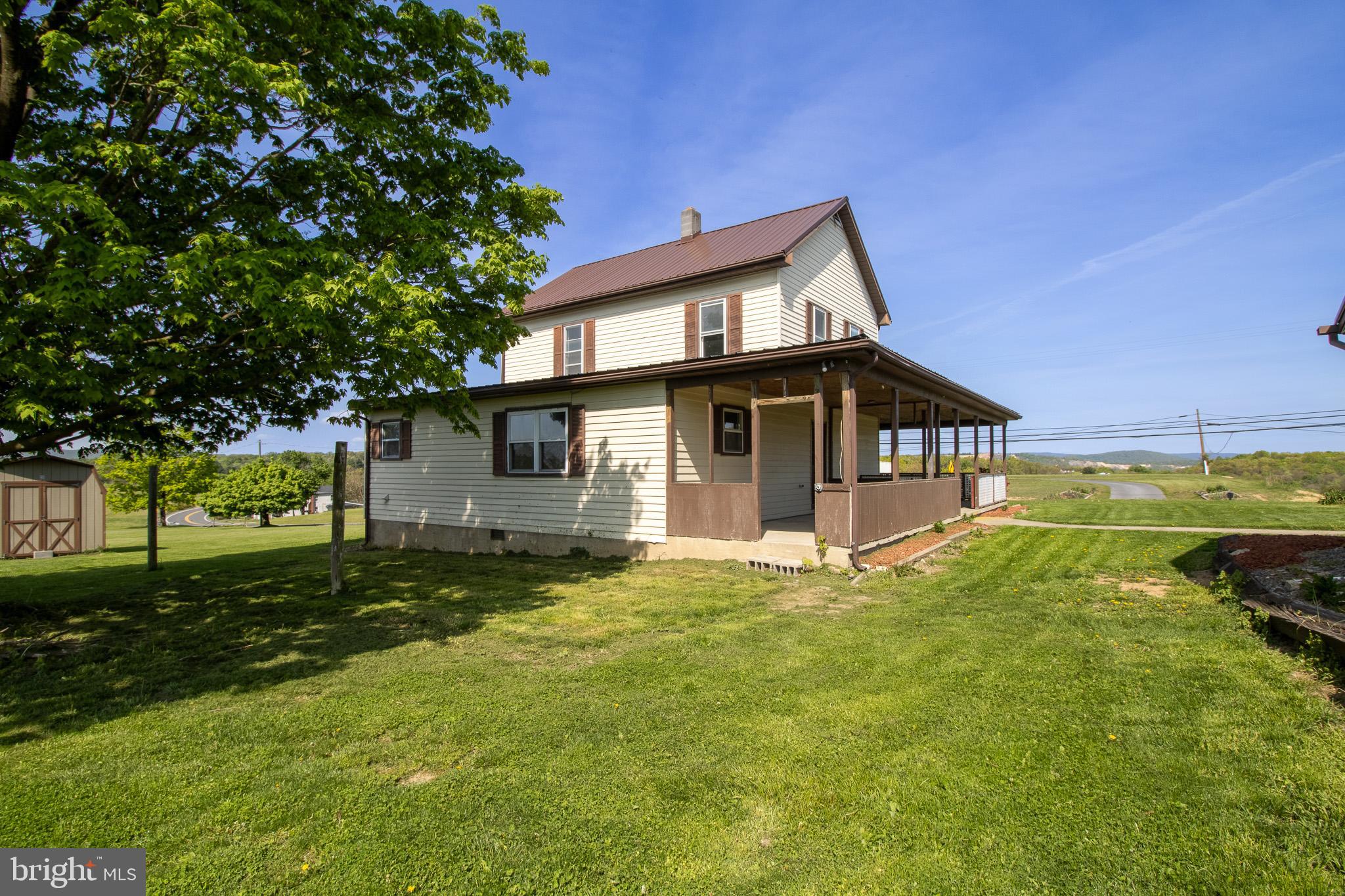 If you like large covered porches then this is the house for you!  Nice views from both porches on this country home.  Living, dining, kitchen and an additional family room on the main level.  Full bath and a half bath on the main level as well.  Upstairs are three bedrooms and another half bath.  A large detached garage type building could be completed as a business or another living quarters.