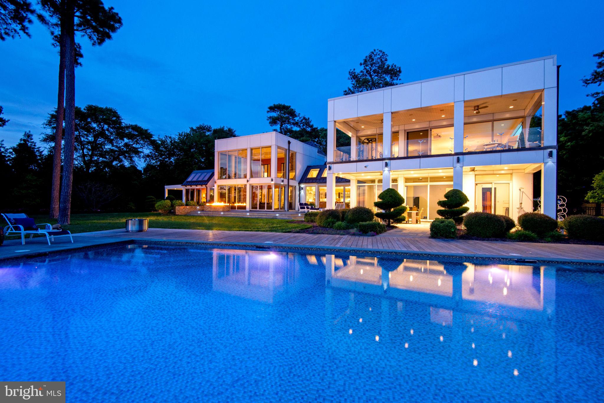Perched on the York River’s most coveted shoreline, Tyndall Point is a visionary architectural triumph blending Virginia masterpiece with striking modernity. Reimagined by renowned architect Randall Kipp, the original 1968 colonial was transformed into a 7000 square foot smart estate where elegance meets cutting-edge design. Walls of glass frame breathtaking water views from three exposures, with nightly sunsets over the infinity pool offering a cinematic backdrop. A chef’s kitchen with Wolf + Sub-Zero appliances, theater, gym, solarium, and full bar create a private resort experience. Whole-house automation controls lighting, blinds, audio, and climate via app or built-in iPads. Car enthusiasts will love the oversized tiled garage; boaters the deep-water dock with 10,000 lb lift and waterfront sun deck and direct access to the Chesapeake Bay. Solar, geothermal, radiant floor heat—luxury meets sustainability. Moments from Yorktown & Williamsburg, yet a world away.